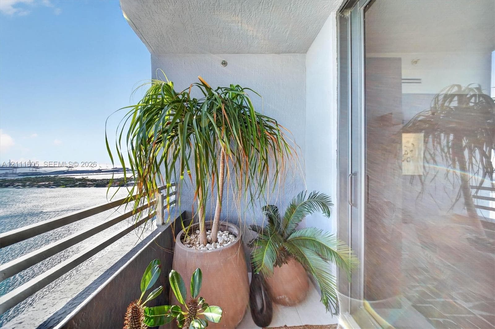 Private balcony featuring horizontal metal railings and sliding glass doors