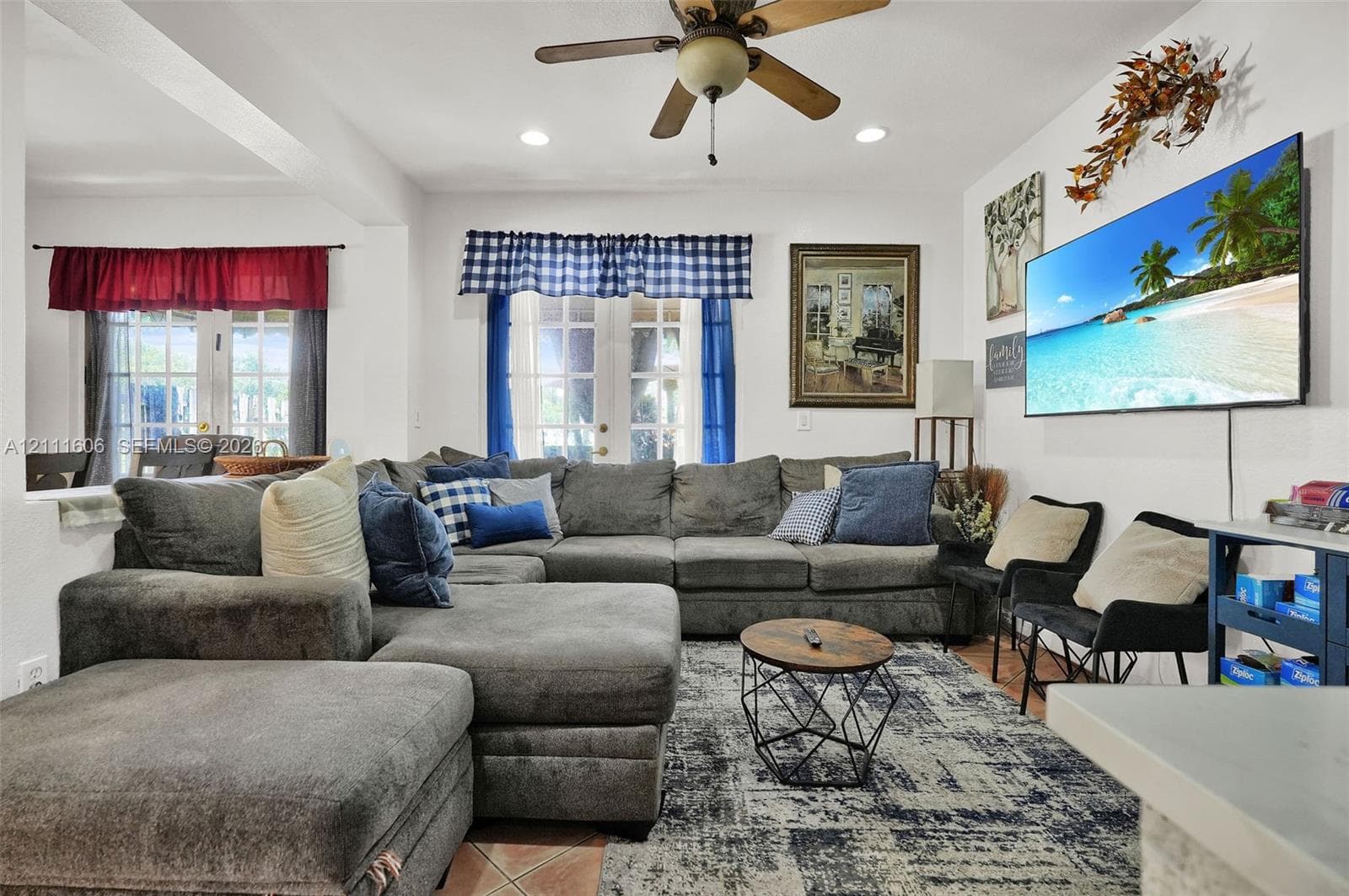 Living area featuring tile flooring, ceiling fan, recessed lighting, and dual sets of French doors