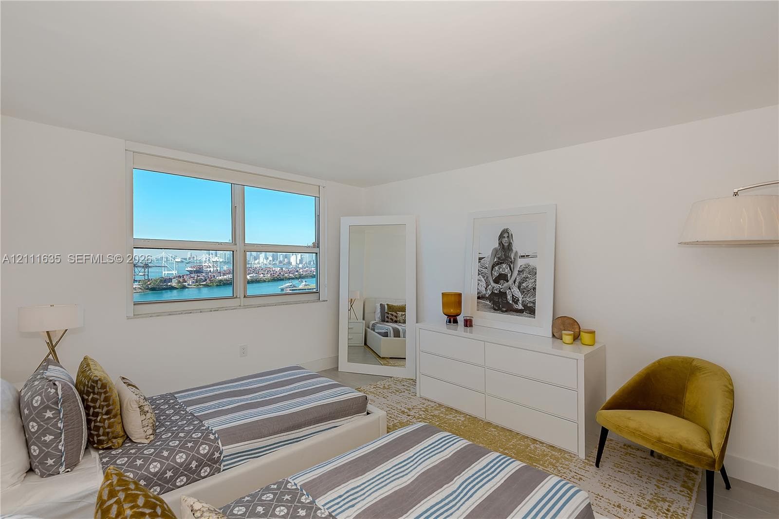 Interior space featuring large-scale windows with water and skyline scenery and neutral wall finishes