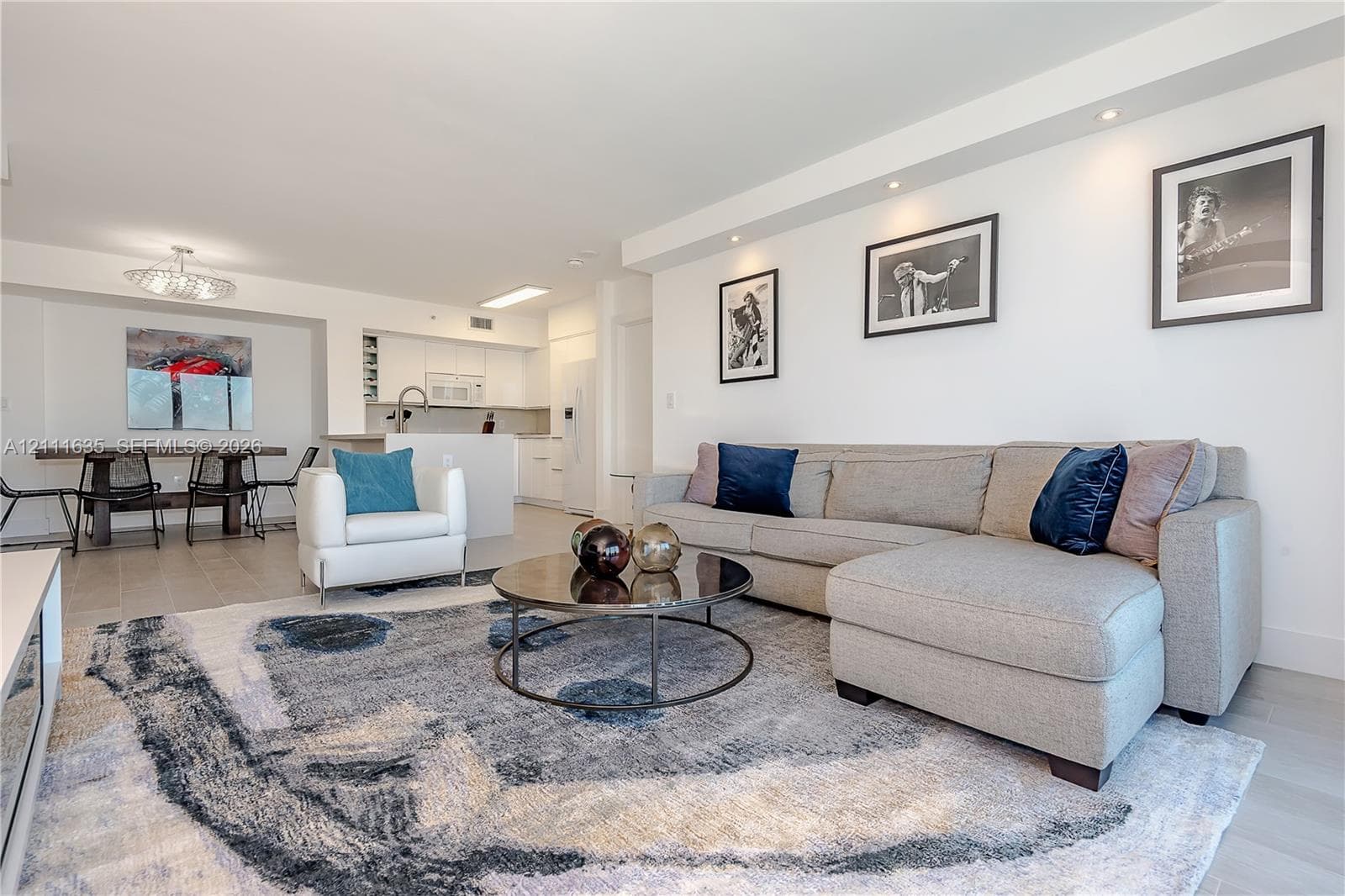 Open-concept interior featuring recessed ceiling lighting, light-toned wood-finish flooring, a kitchen breakfast bar, and neutral walls