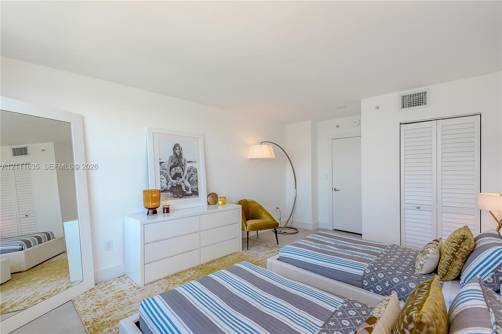 Neutral interior space featuring white walls, smooth-finish ceiling, and double-door closet with louvered panels