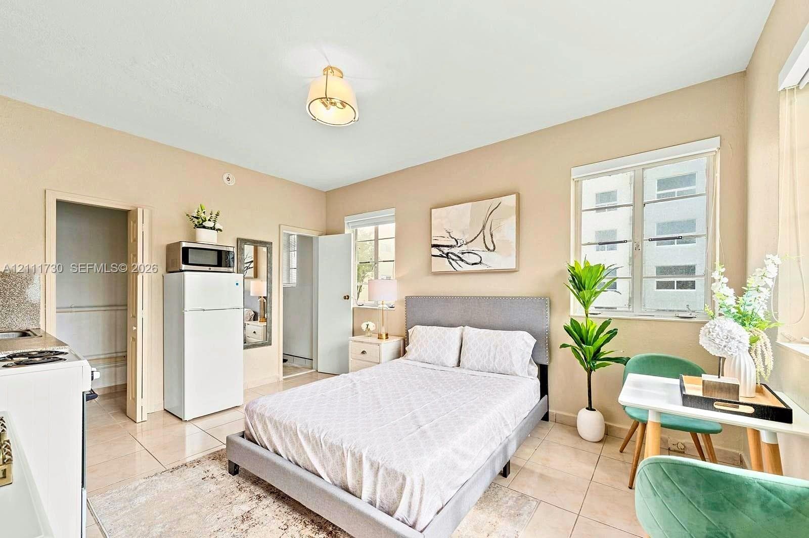 Studio interior featuring large-format tile flooring, multi-pane windows, and a flush-mount light fixture