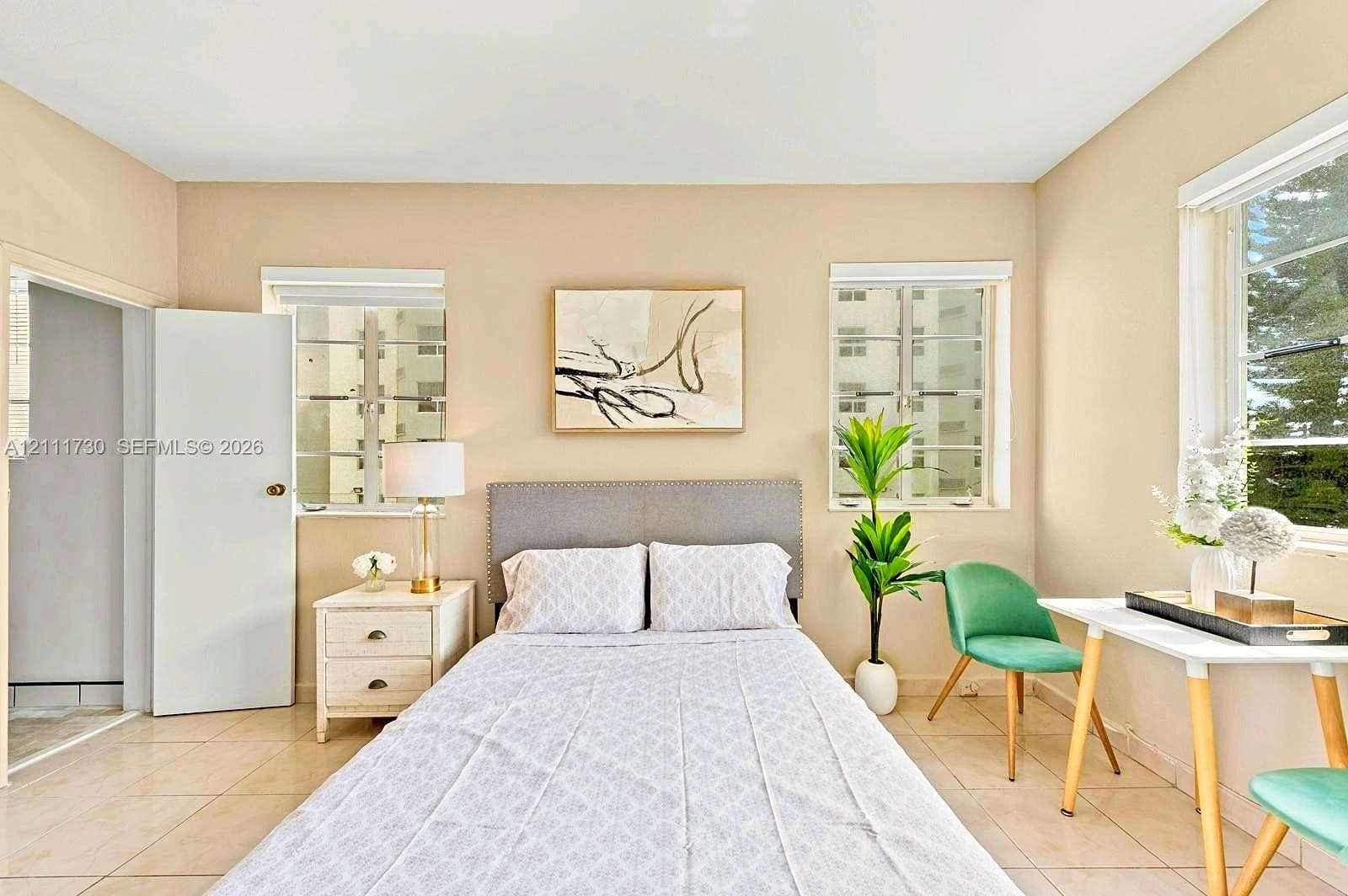 Neutral-toned interior featuring ceramic tile flooring, dual-pane windows, and a classic swinging door