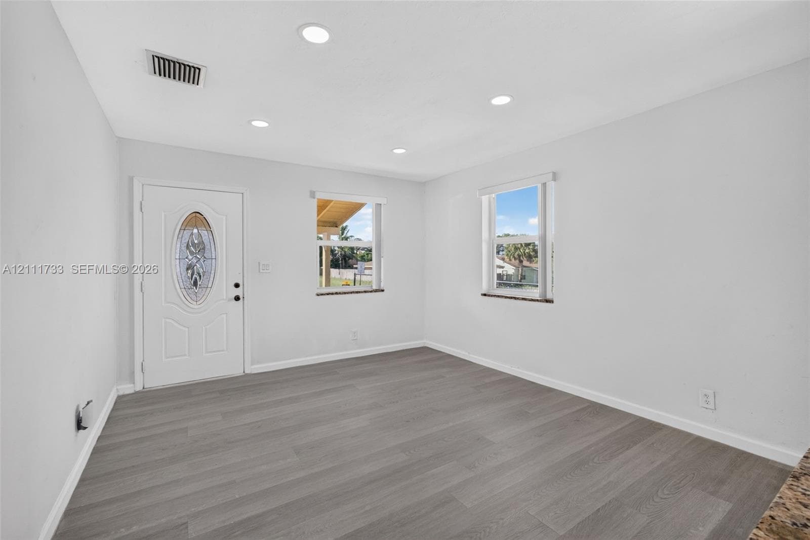 Interior space featuring wood-finish flooring, recessed lighting, and an exterior door with an oval decorative glass insert