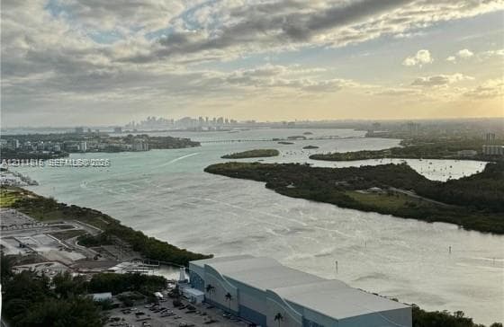 Panoramic bay and coastal skyline scenery featuring expansive water frontage, mangrove-lined shorelines, and distant urban horizon