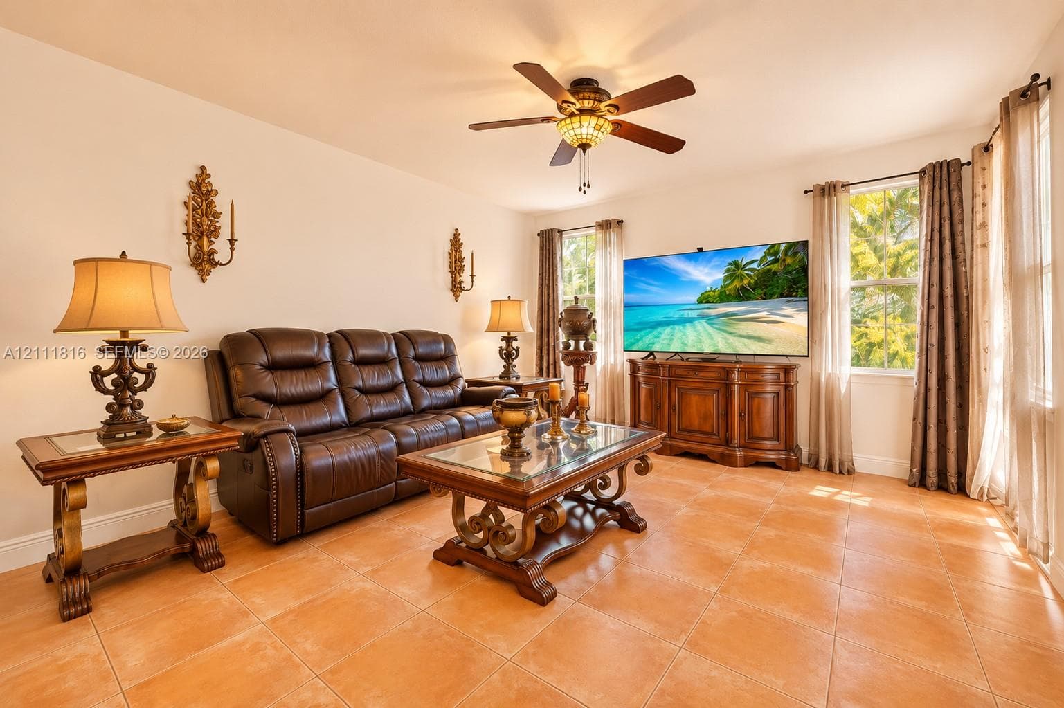 Ceramic tile flooring, ceiling fan with integrated lighting, and dual wall-mounted ornamental sconces