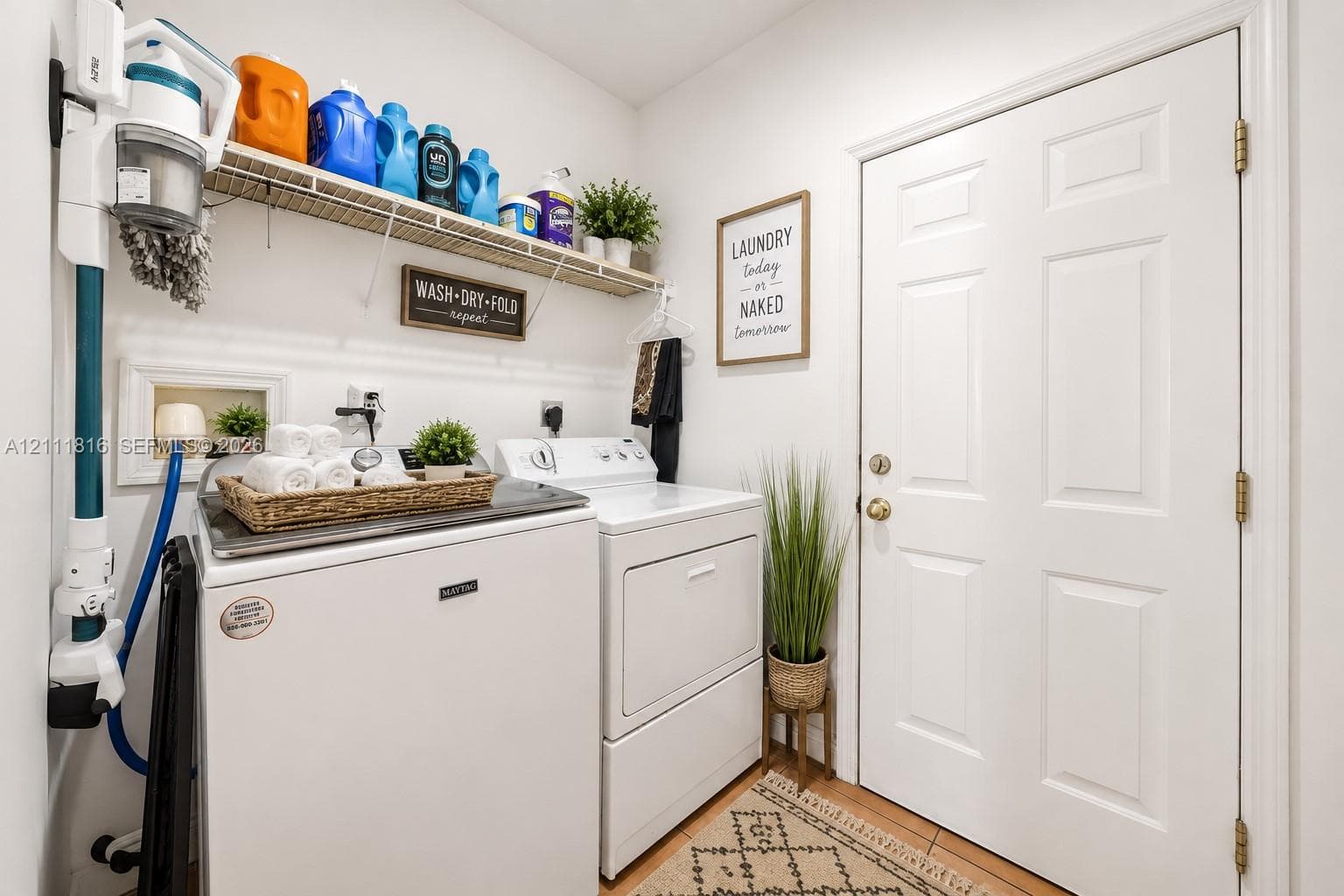Laundry area featuring white appliance hookups, wall-mounted wire shelving, and a six-panel door