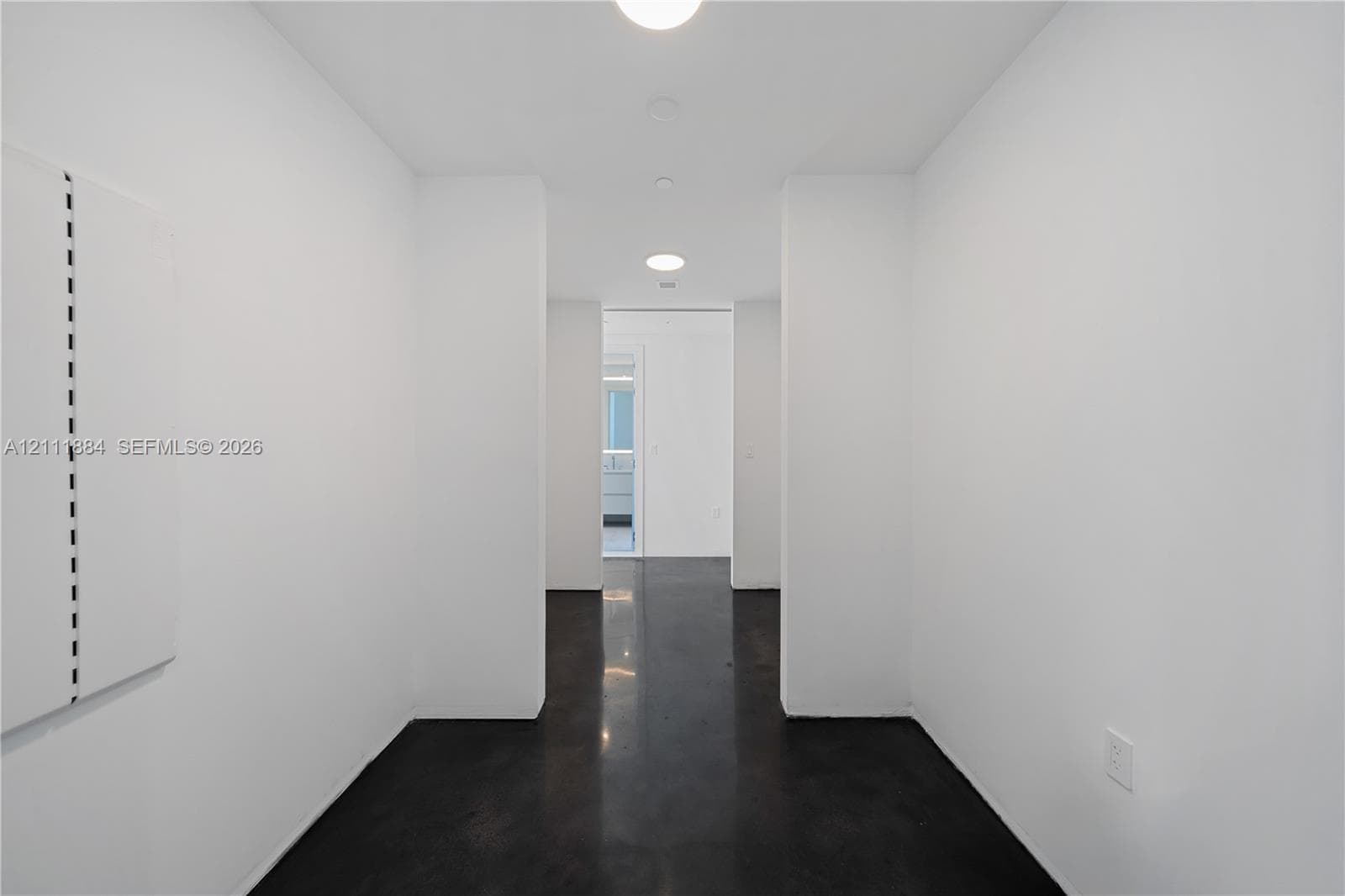 Polished concrete flooring, smooth white walls, and recessed ceiling lighting