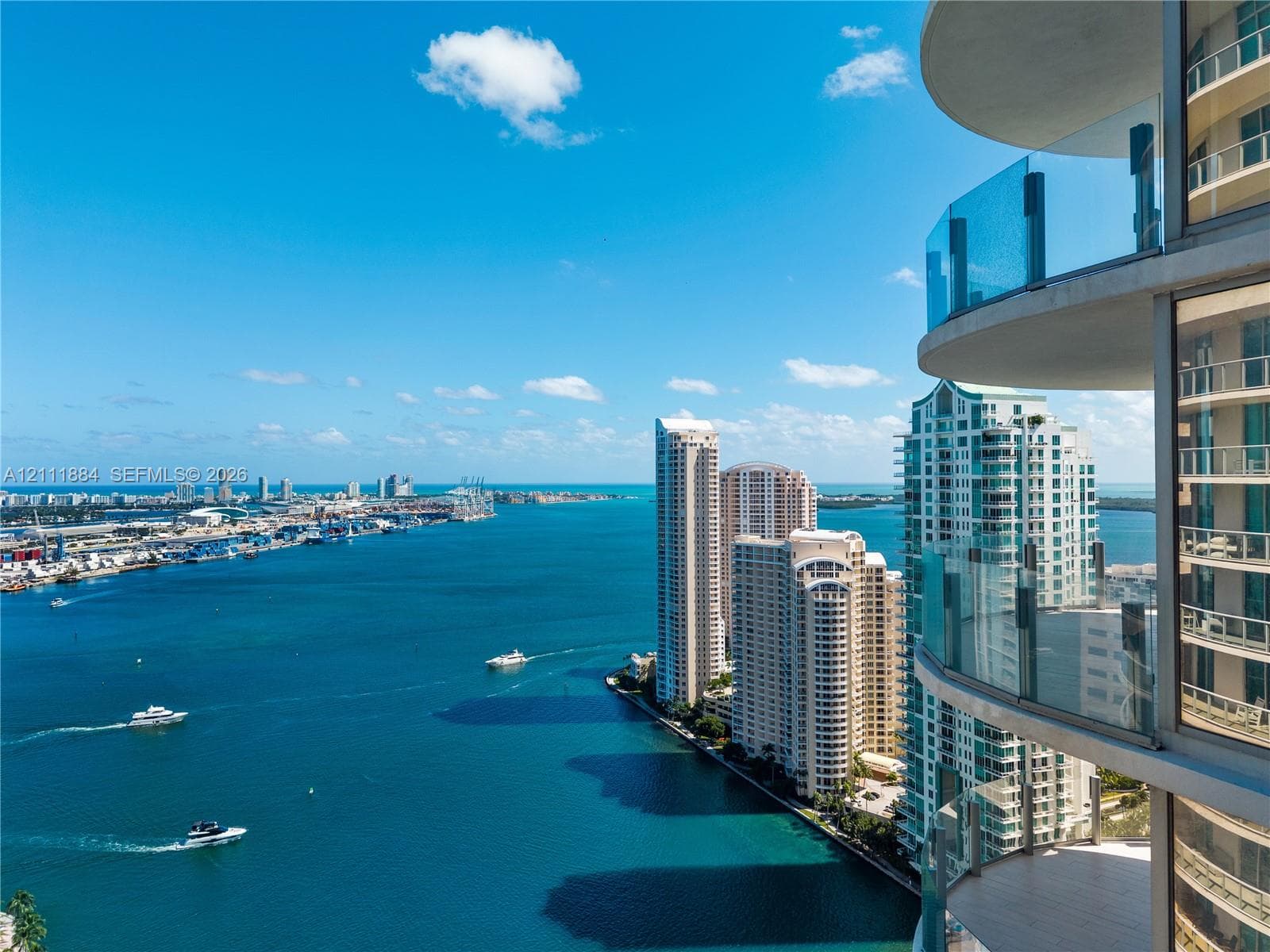 Curved private balconies with glass railings featuring floor-to-ceiling windows