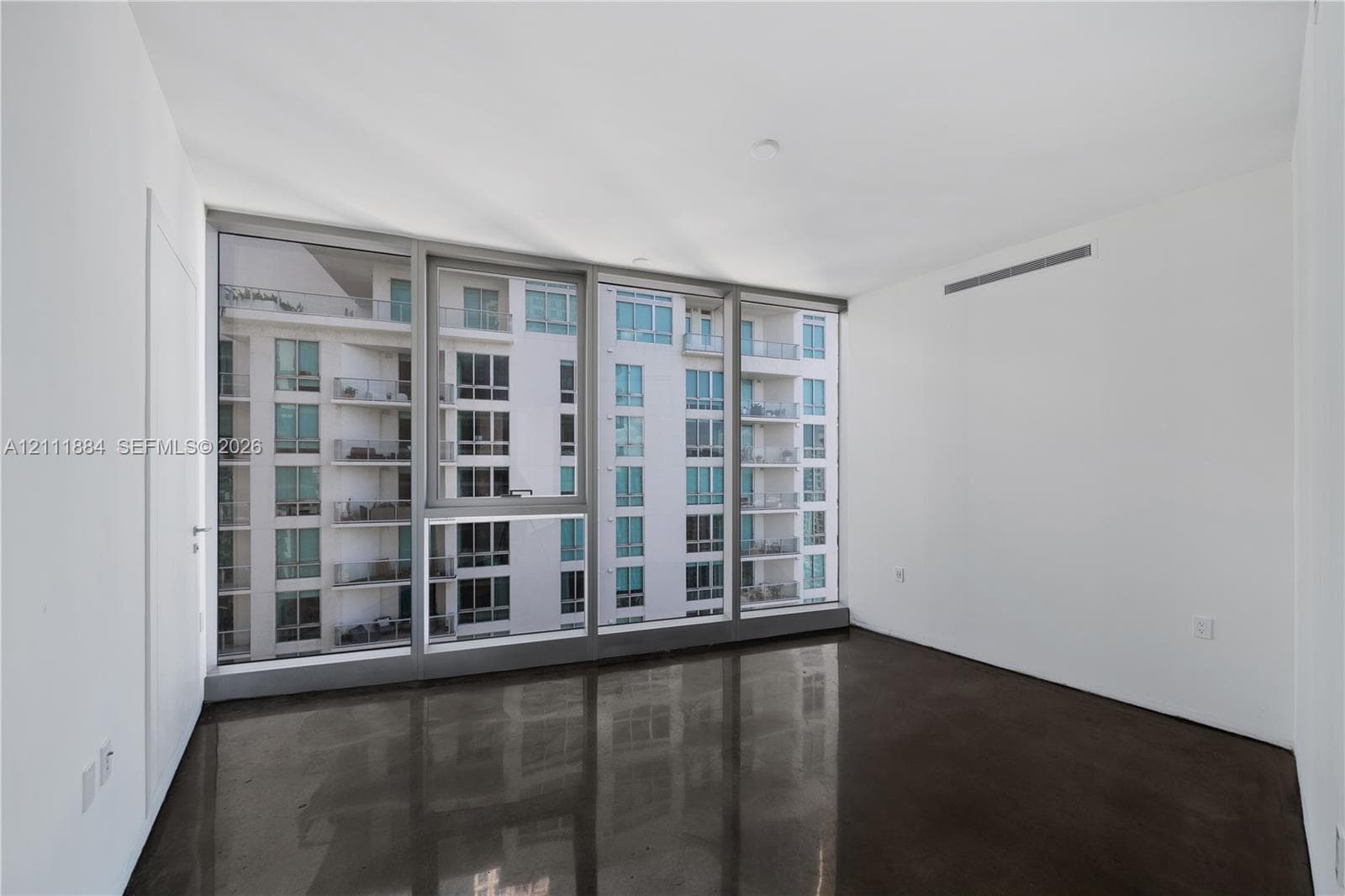 Floor-to-ceiling windows with metal framing and polished concrete flooring