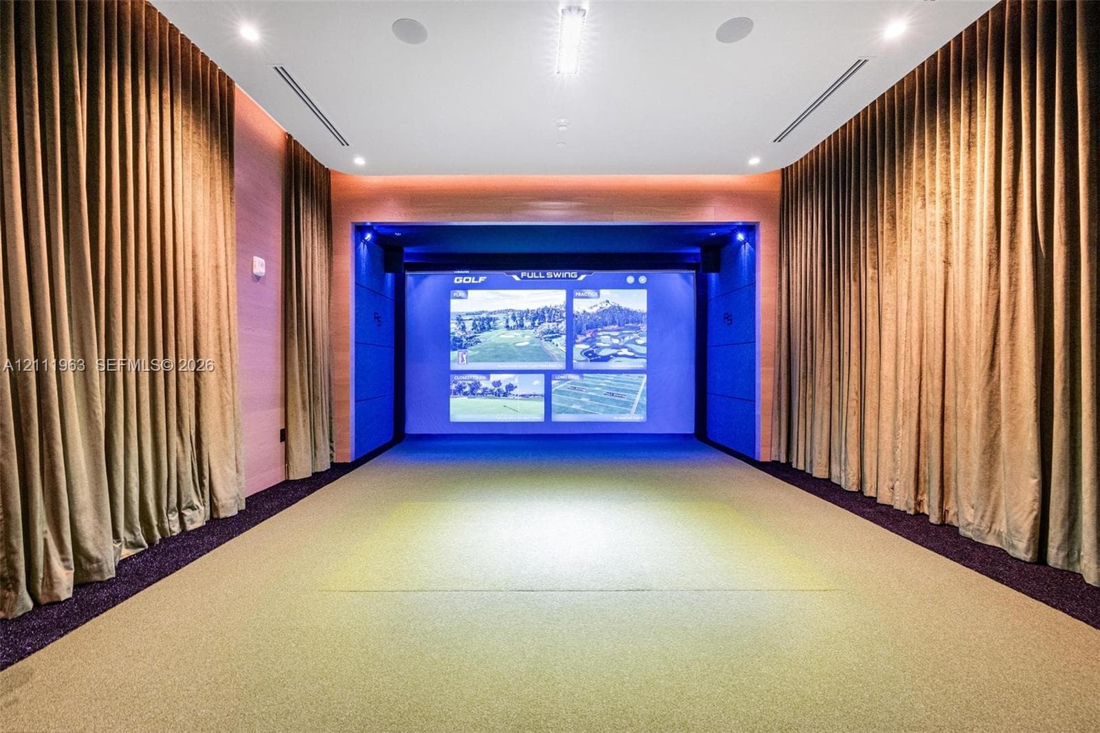 Dedicated simulator room featuring a high-definition projection screen, recessed ceiling lighting, integrated audio speakers, and wall-to-wall carpeting