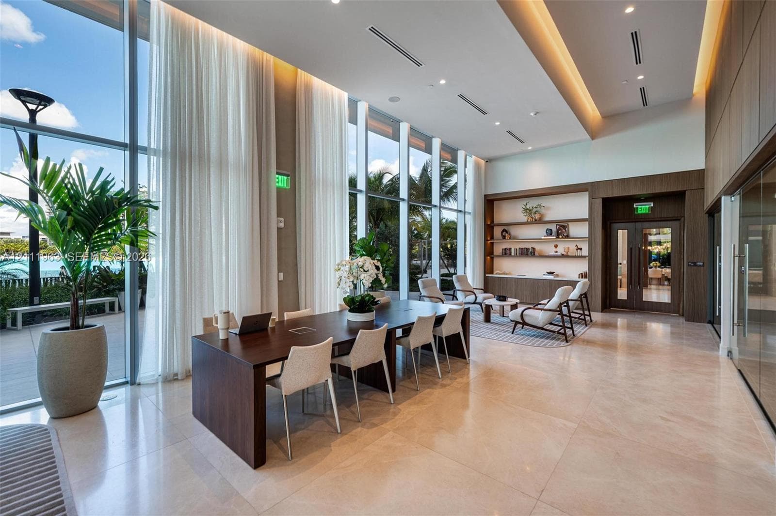 Floor-to-ceiling windows, polished stone flooring, recessed ceiling lighting, and built-in wood shelving