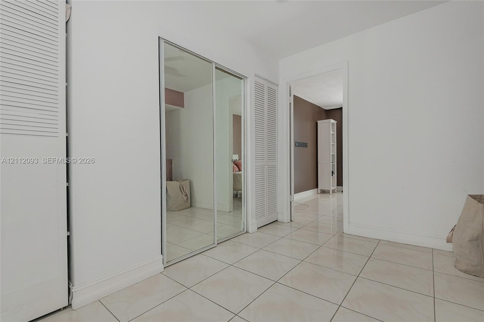 Tiled flooring, floor-to-ceiling mirrored sliding closet doors, and bi-fold closet doors
