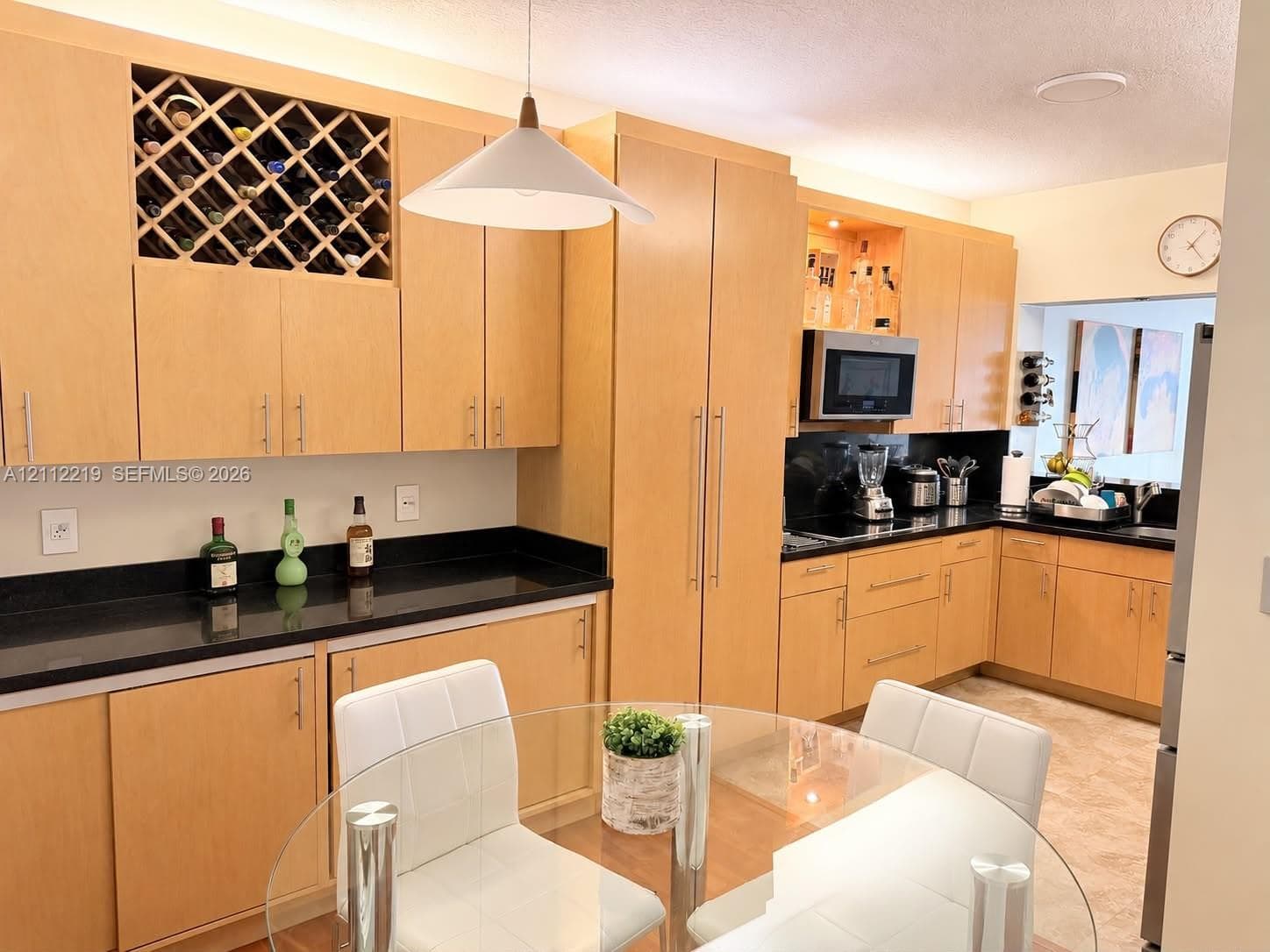 Wood-finish flooring throughout, wall-mounted display shelving, and built-in cabinetry featuring glass-panel doors