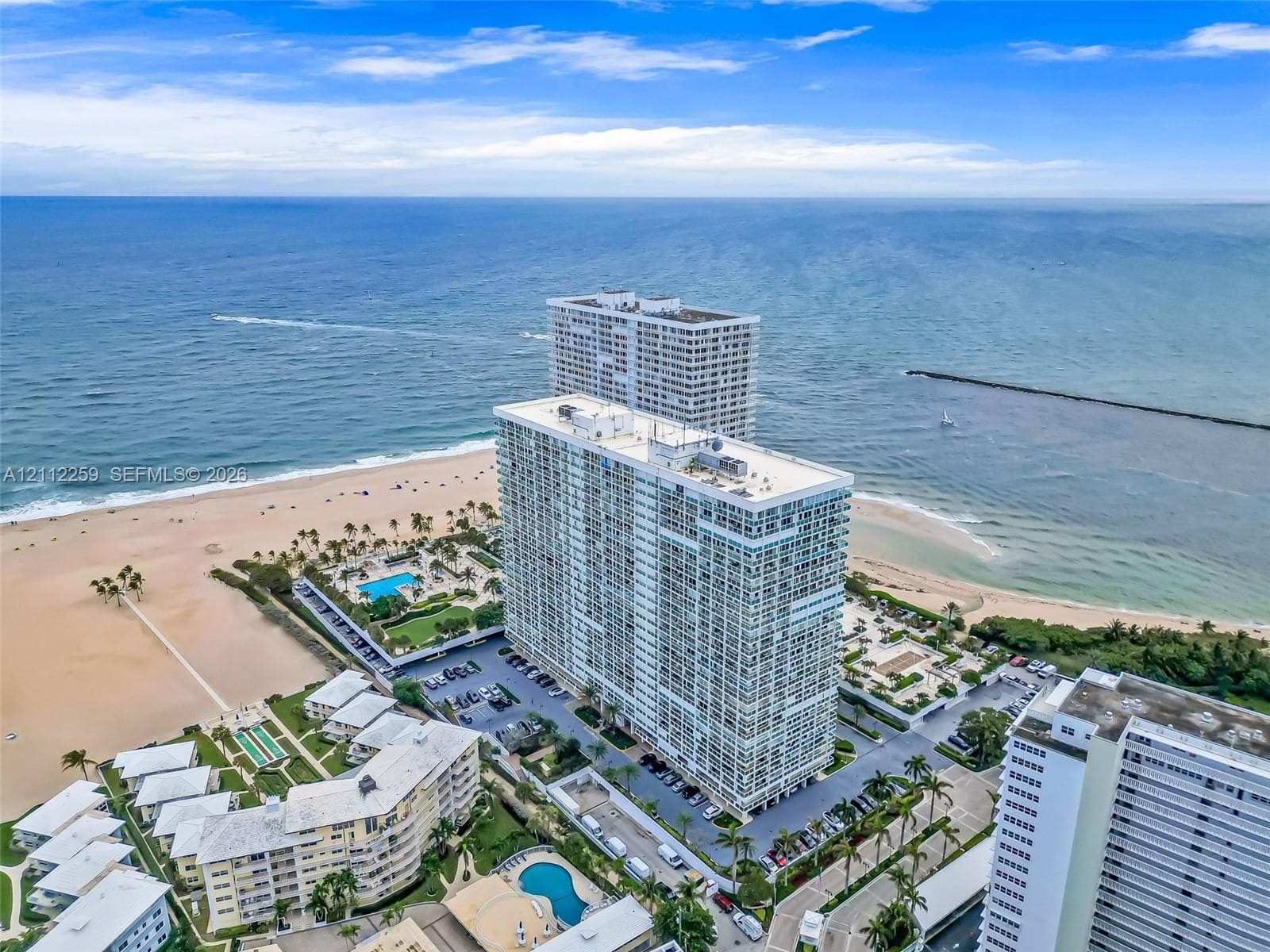 Aerial perspective featuring coastal shoreline, ocean access, waterway inlet, and multi-story residential structures