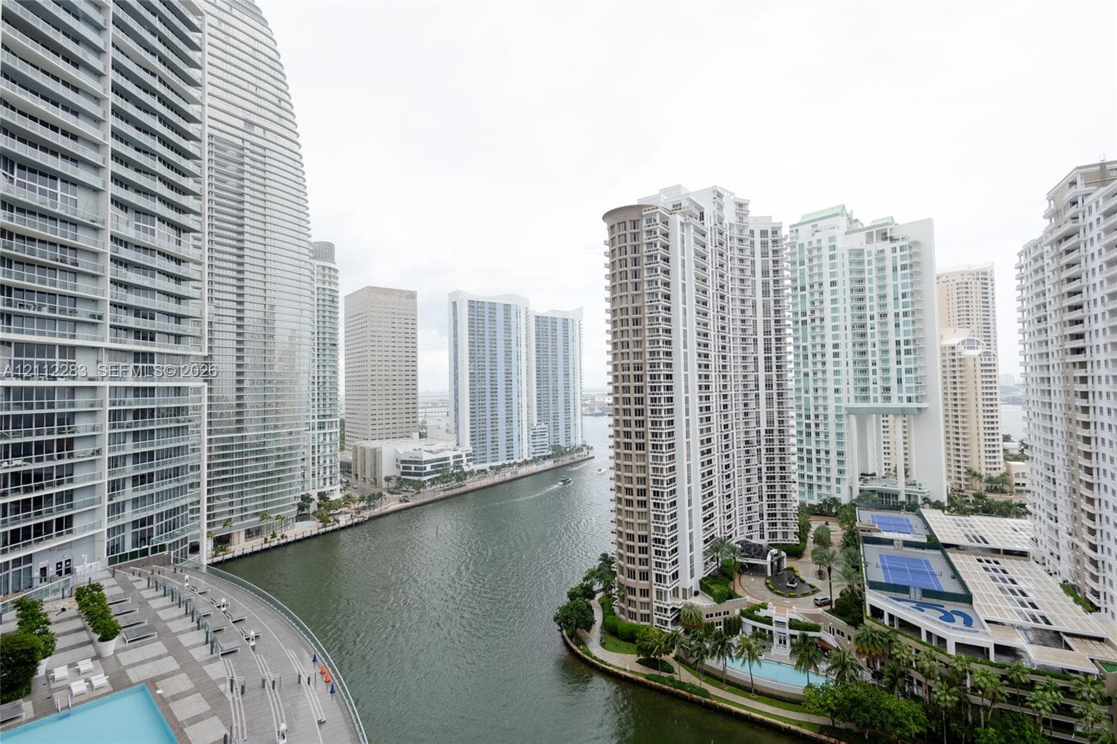 Elevated urban perspective featuring high-rise architecture, waterway frontage, and a podium-level swimming pool