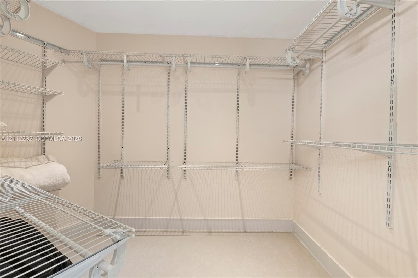 Walk-in closet featuring adjustable wire shelving and a vertical track mounting system