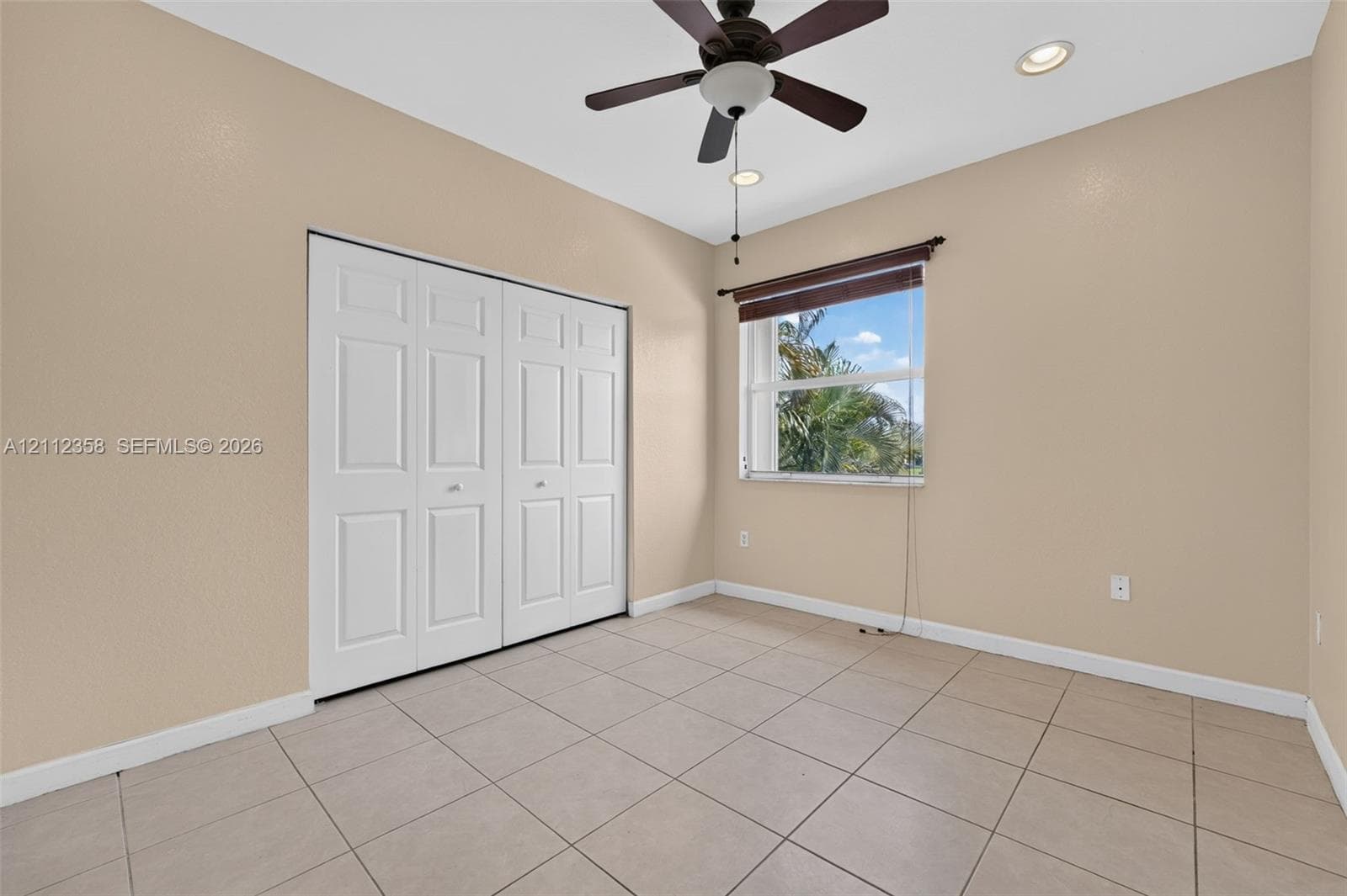 Room featuring tile flooring, ceiling fan with integrated lighting, recessed lighting, and double-door closet