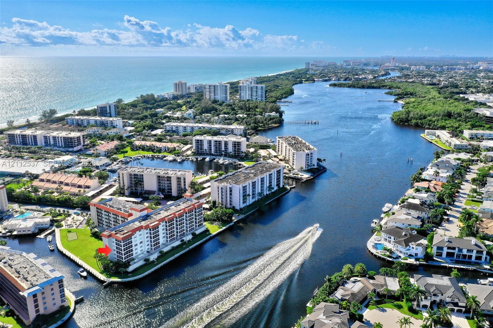 Aerial perspective of coastal multi-story residential building featuring waterfront positioning, expansive waterway exposure, and proximity to shoreline