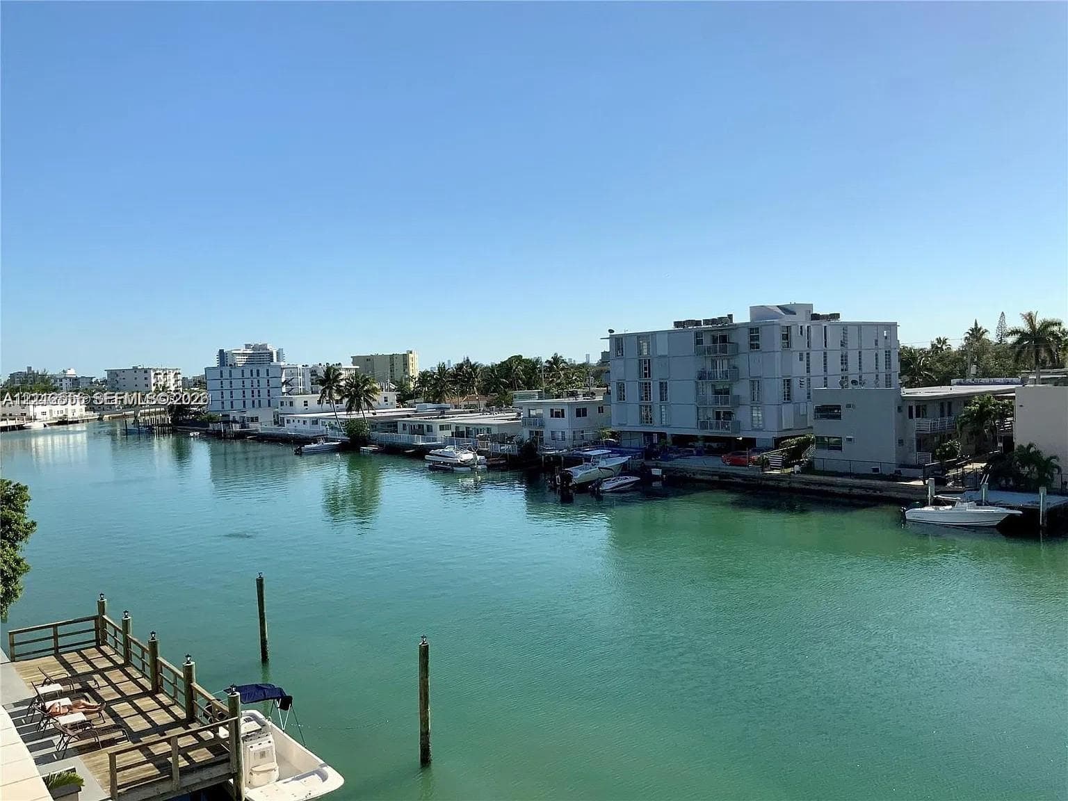 Waterfront property featuring a private wooden dock, concrete seawall, and direct waterway access
