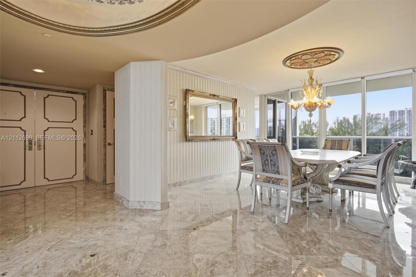 Polished stone flooring, custom ceiling moulding, decorative ceiling medallion, ornate chandelier, and full-height windows