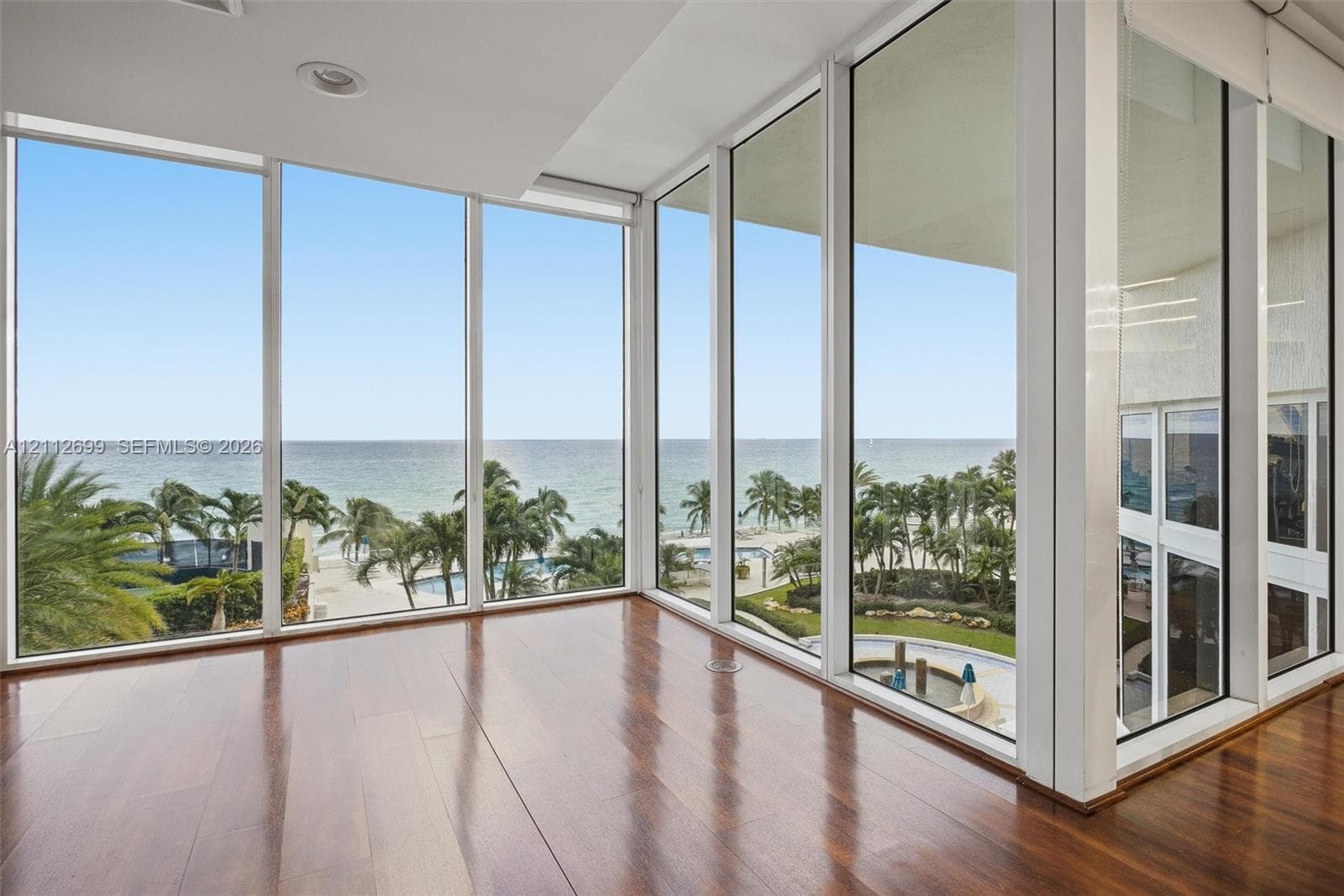 Floor-to-ceiling glass windows, wood-finish flooring, and recessed lighting