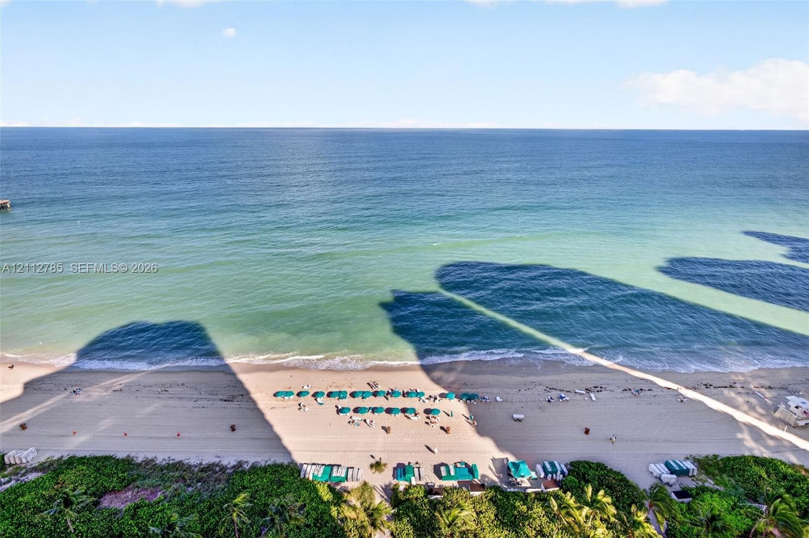 Direct oceanfront exposure with panoramic water horizon and expansive sandy beach