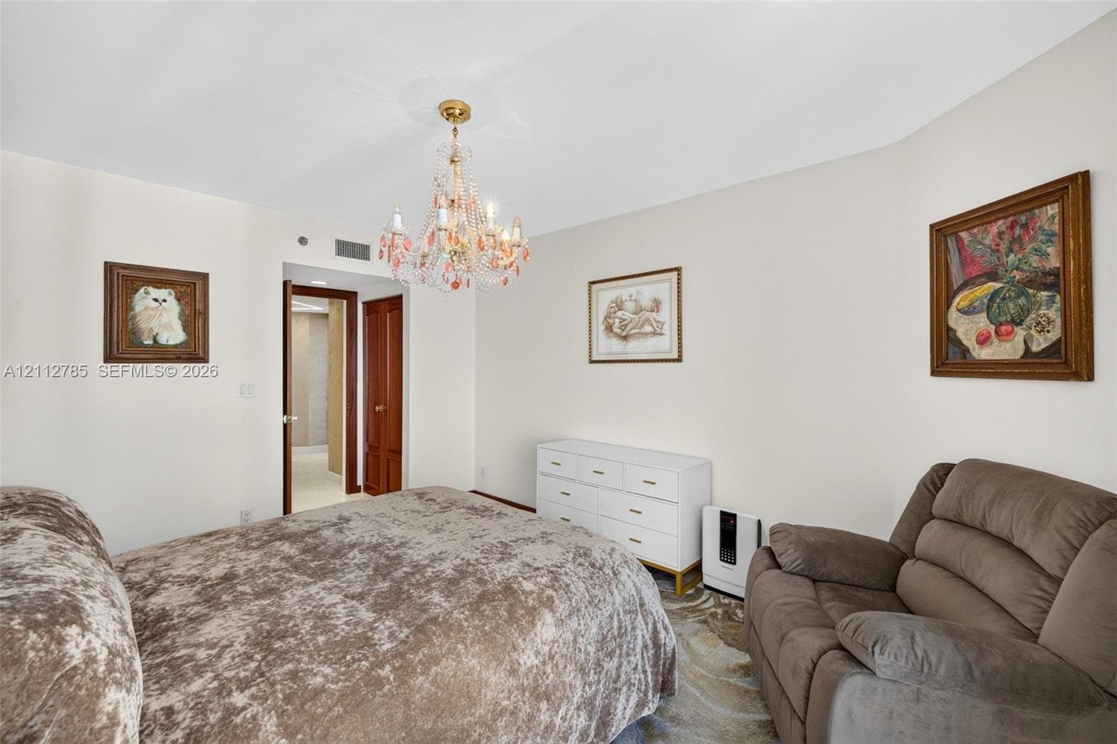 Multi-faceted glass chandelier with gold-tone finish and solid wood interior doorway