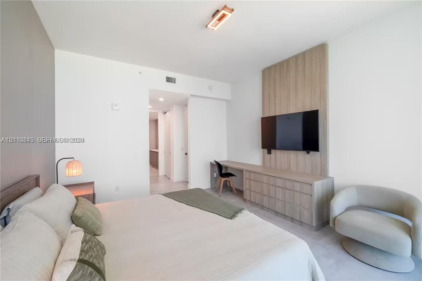 Custom floor-to-ceiling wood-finish wall paneling, integrated built-in cabinetry, streamlined desk workstation, and modern rectangular flush-mount ceiling lighting