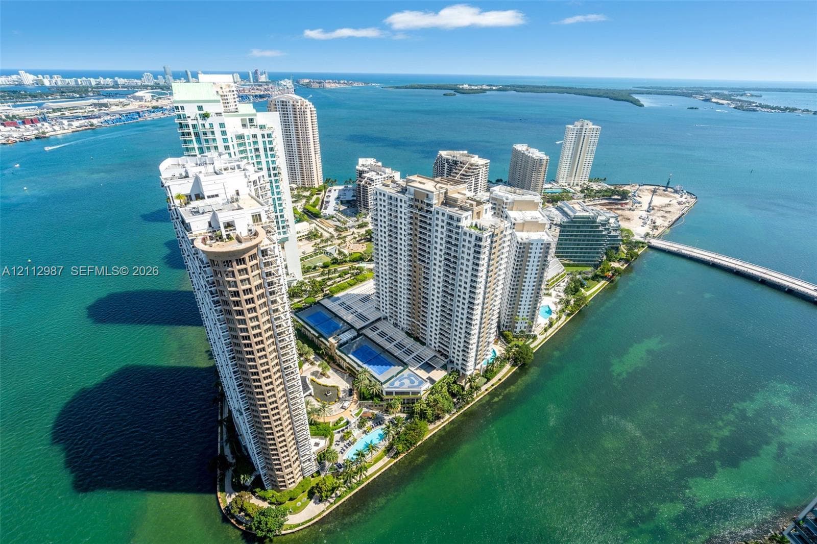 High-rise waterfront complex featuring multiple outdoor swimming pools, landscaped grounds, tennis courts, and immediate proximity to the Atlantic shoreline