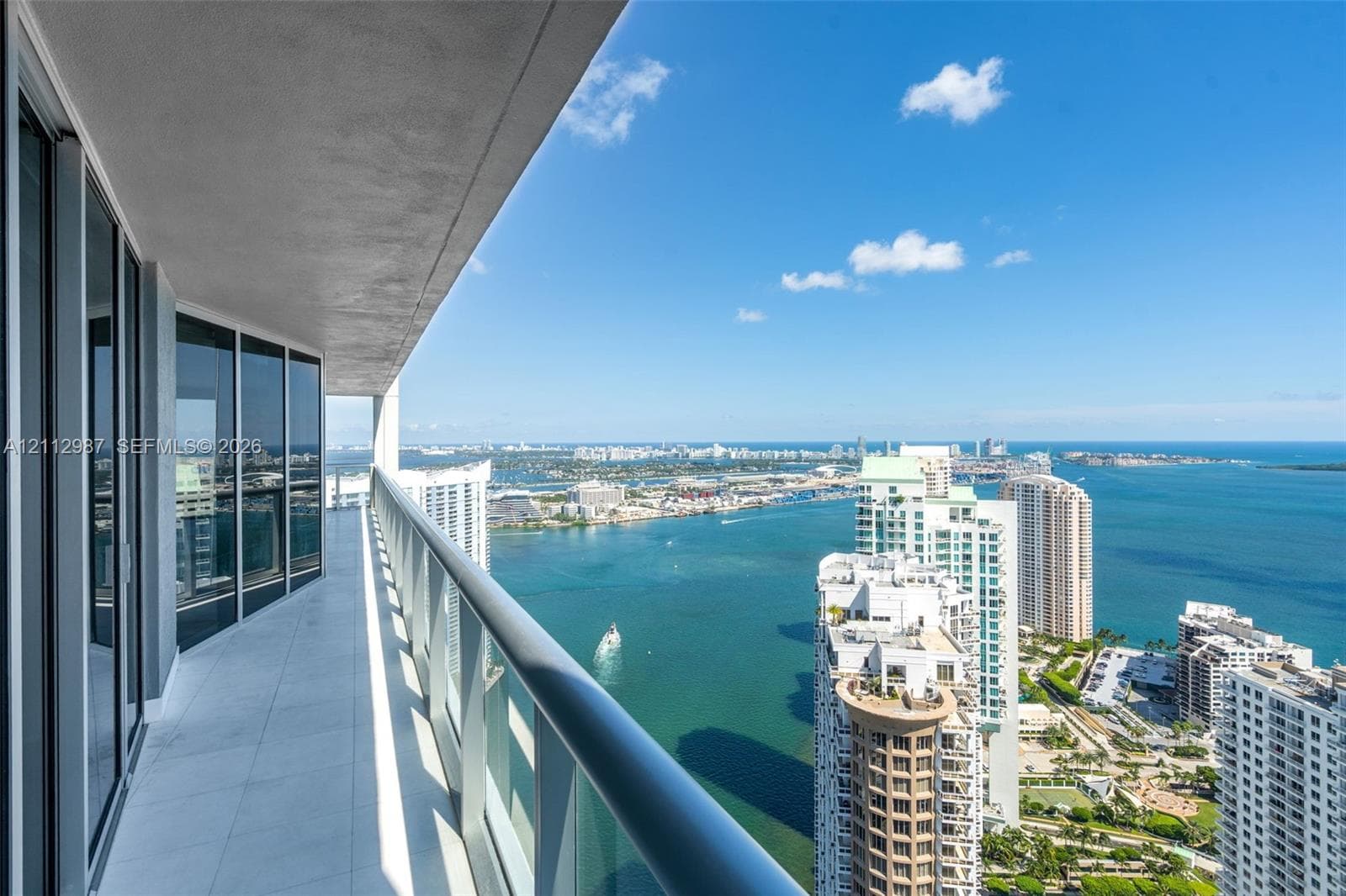 Covered balcony featuring tile flooring and a glass panel railing