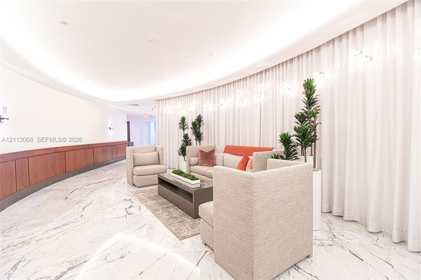 Curved architecture featuring polished stone flooring, recessed ceiling lighting, and wood-panel wainscoting