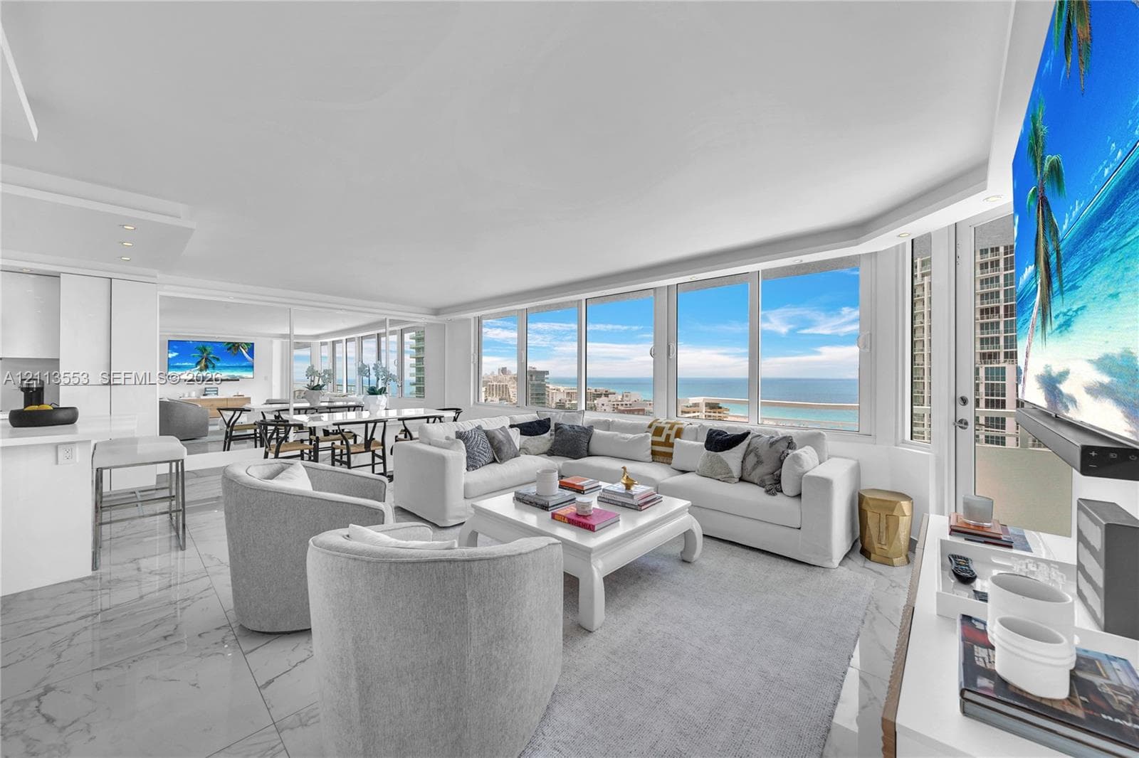 Open-concept living space featuring floor-to-ceiling windows, polished stone-finish flooring, recessed ceiling lighting, and a neutral color palette
