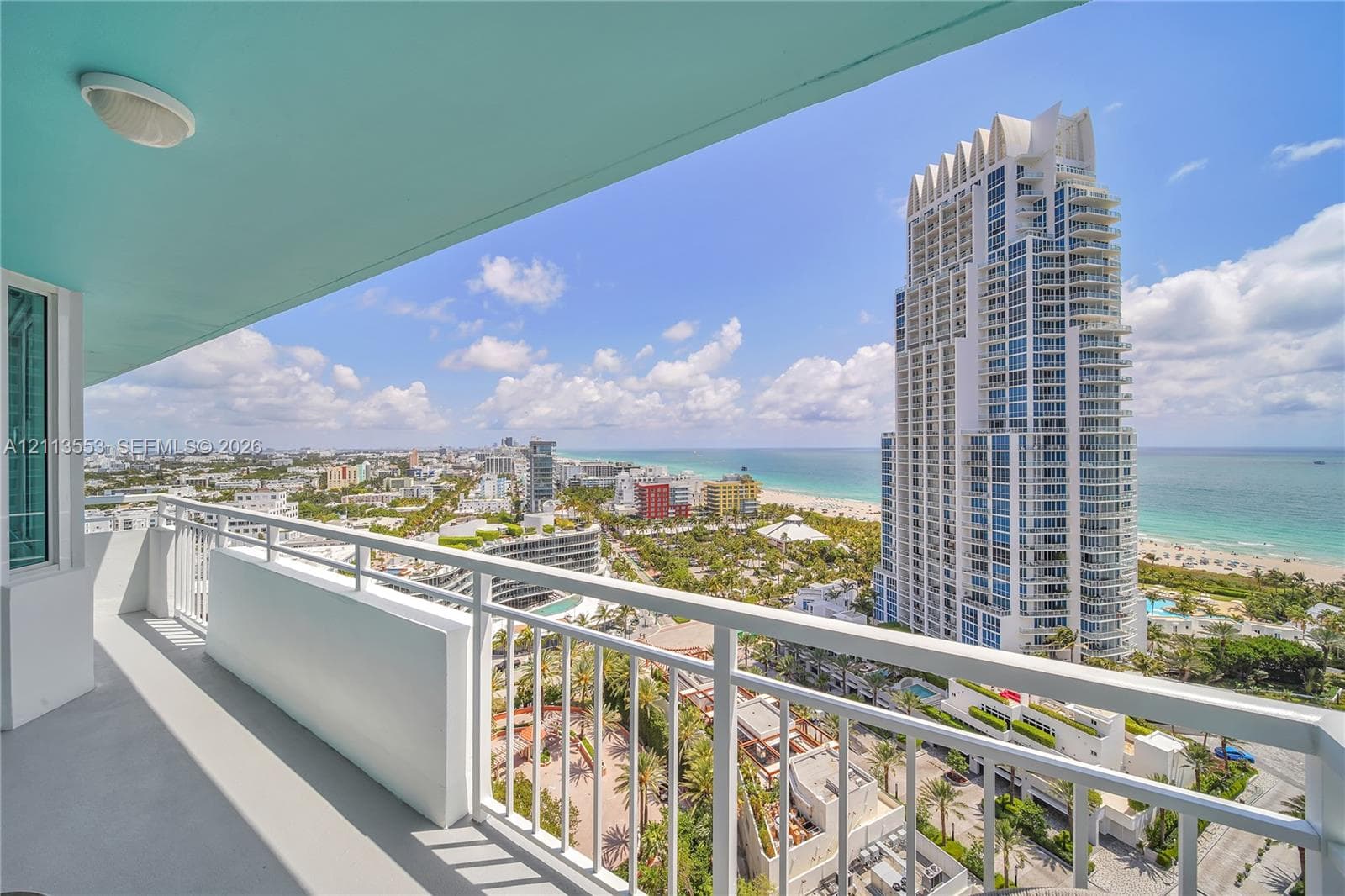 Covered balcony featuring white metal railings and a flush-mount ceiling light