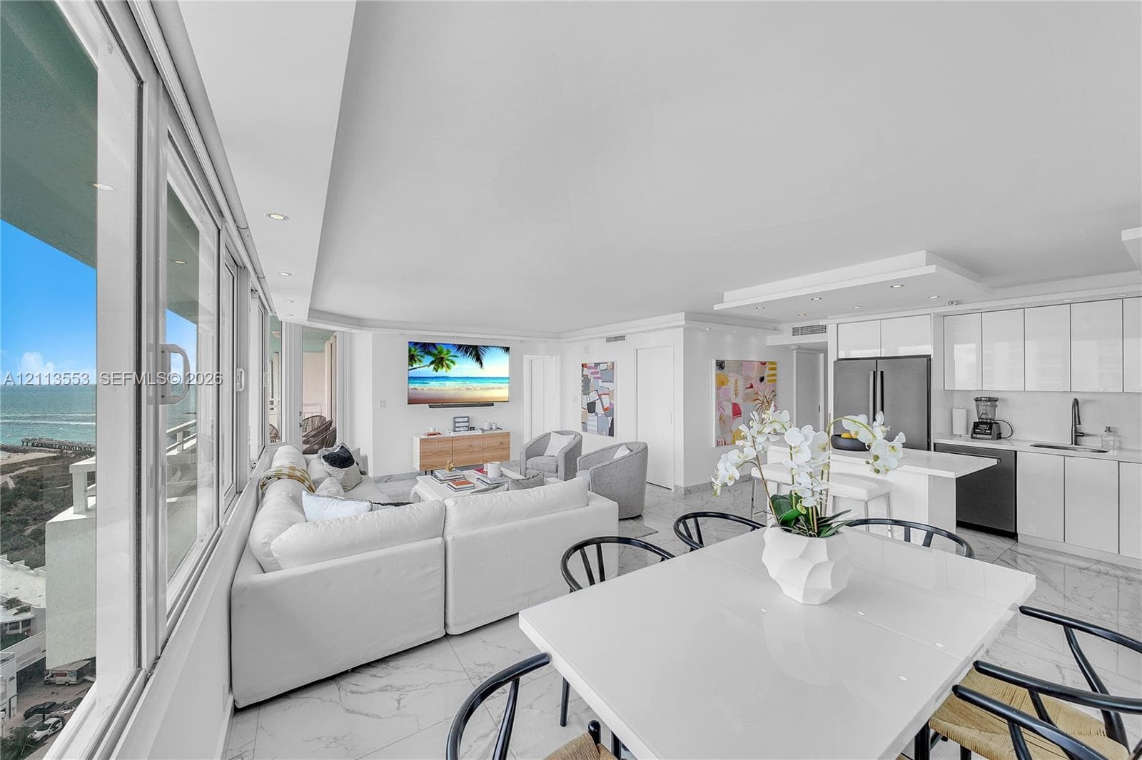 Open-concept interior featuring floor-to-ceiling windows, polished tile flooring, recessed lighting, and white gloss cabinetry