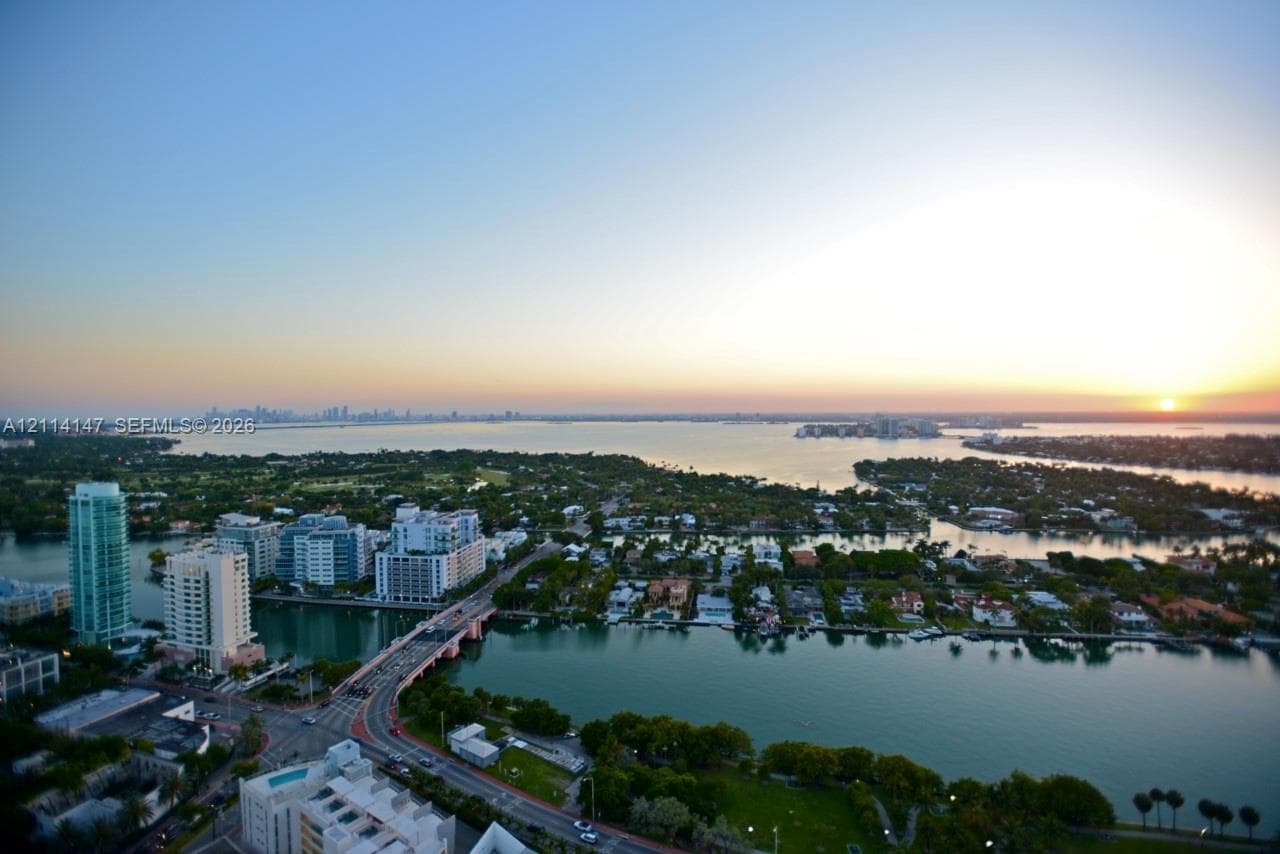 Aerial perspective overlooking coastal waterways, a bridge, metropolitan high-rises, and extensive harbor scenery