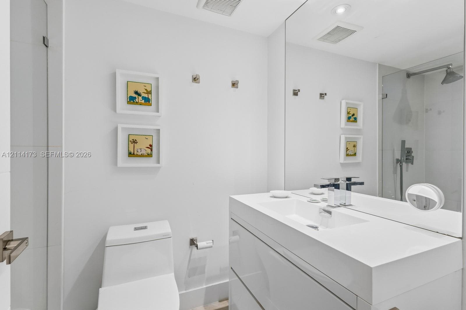 Modern floating vanity with a seamless integrated sink, polished chrome widespread faucet, large-format mirror, and glass-enclosed shower featuring a wall-mounted rainfall showerhead