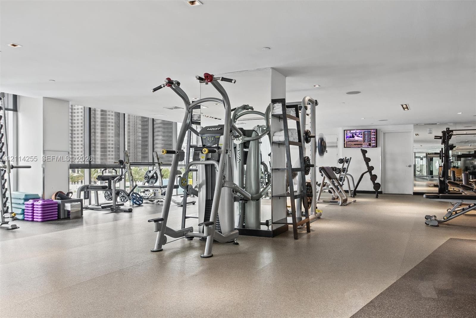 Fitness center featuring floor-to-ceiling windows, recessed lighting, and industrial-grade rubberized flooring