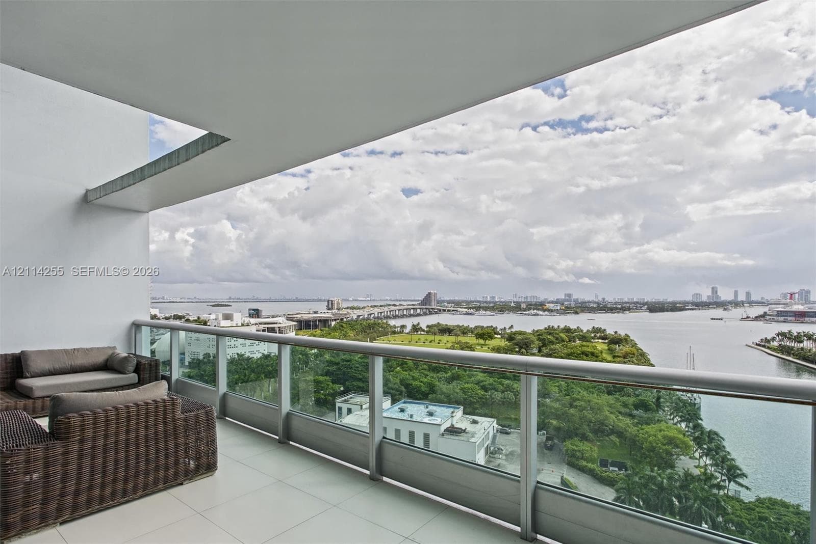 Covered balcony featuring large-format tile flooring and a glass-panel railing