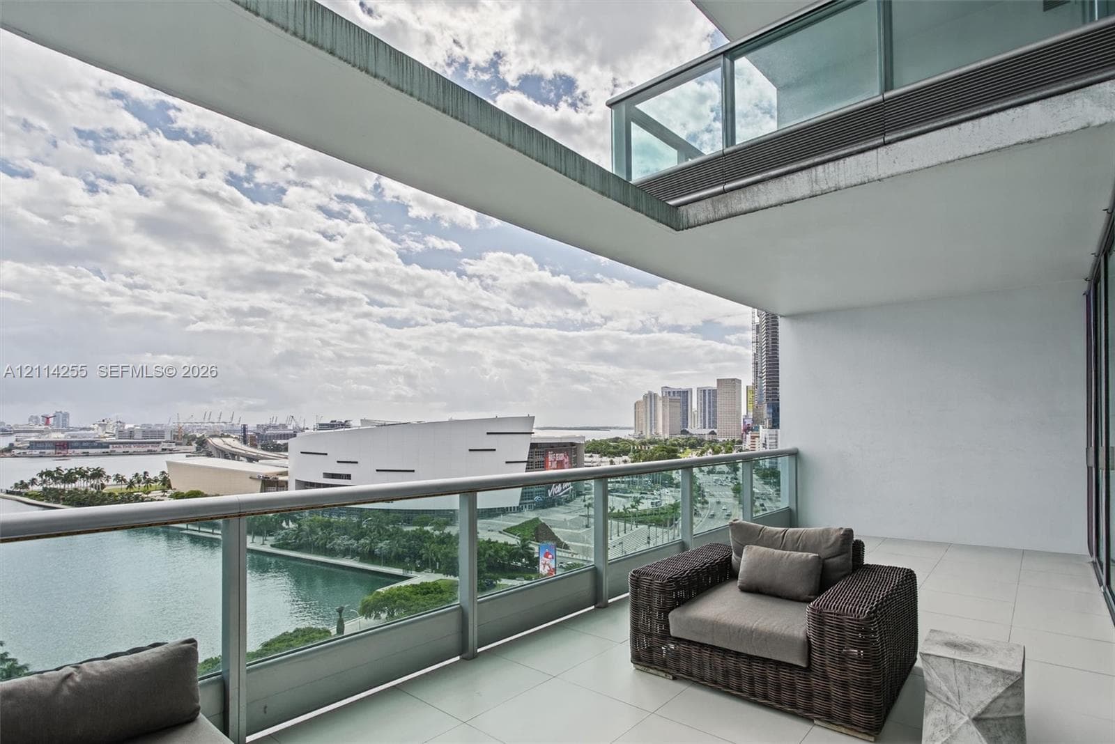 Covered outdoor terrace featuring large-format tile flooring and a glass-panel railing