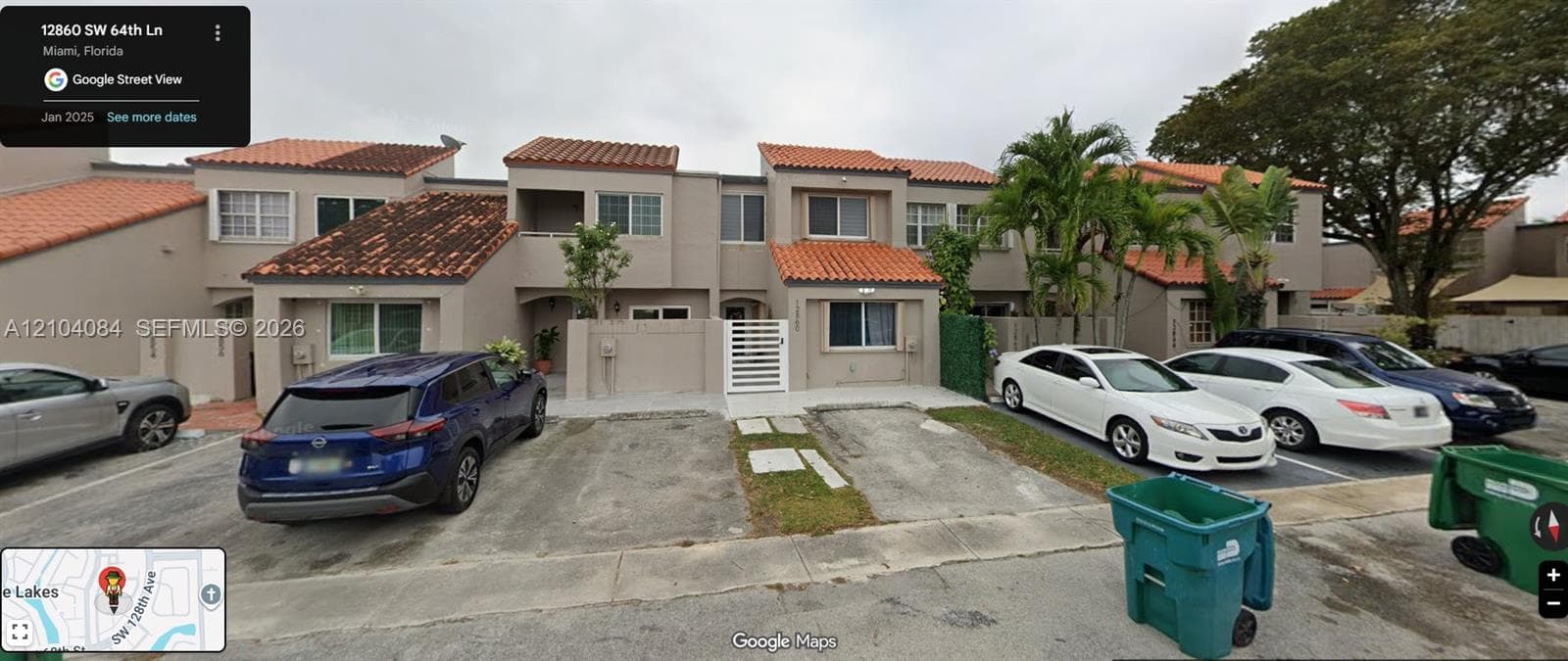 Two-story exterior featuring a clay tile roof, stucco facade, private gated courtyard entry, and dedicated concrete parking pads