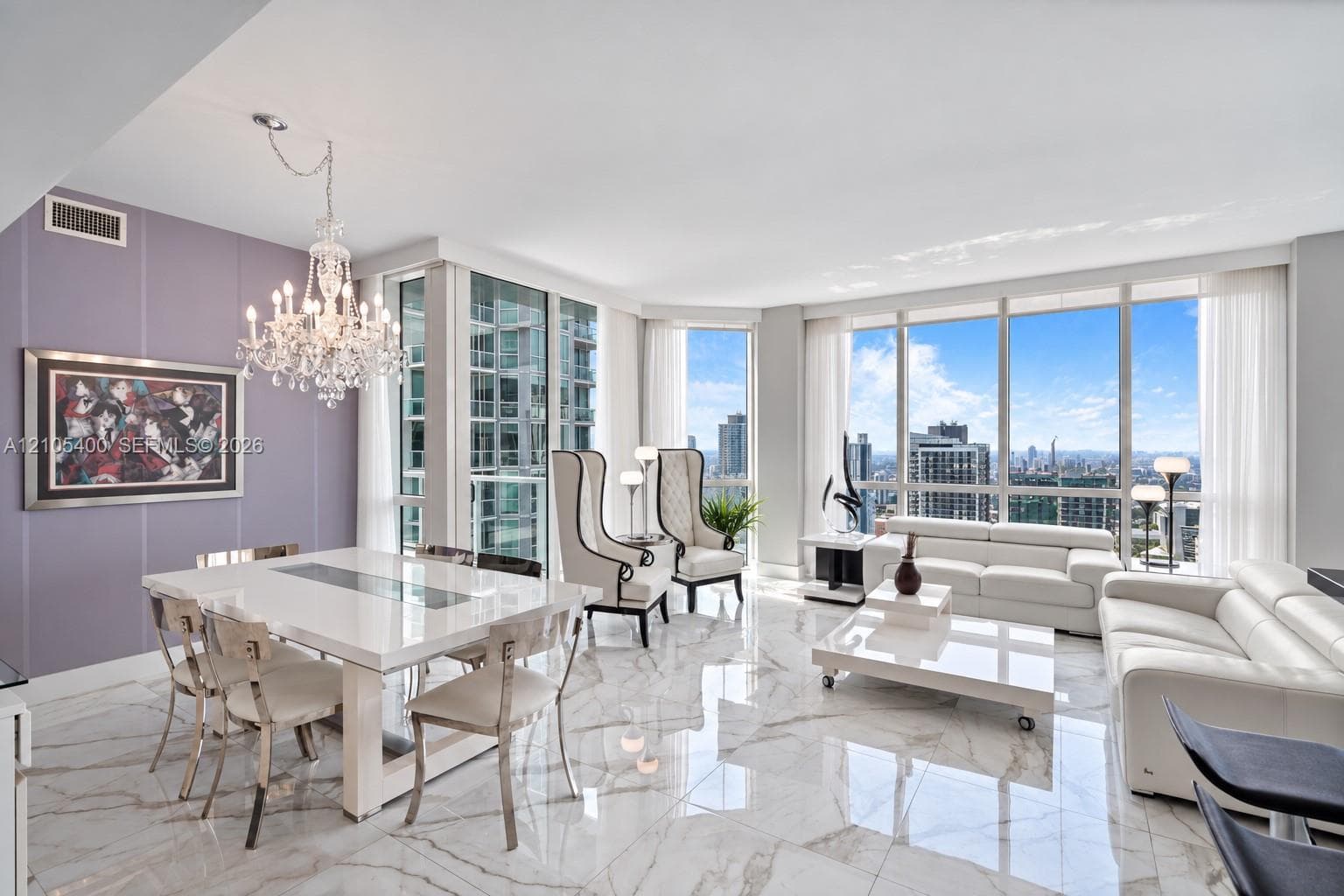 Expansive living area with large floor-to-ceiling windows, polished marble-look flooring, and a crystal chandelier
