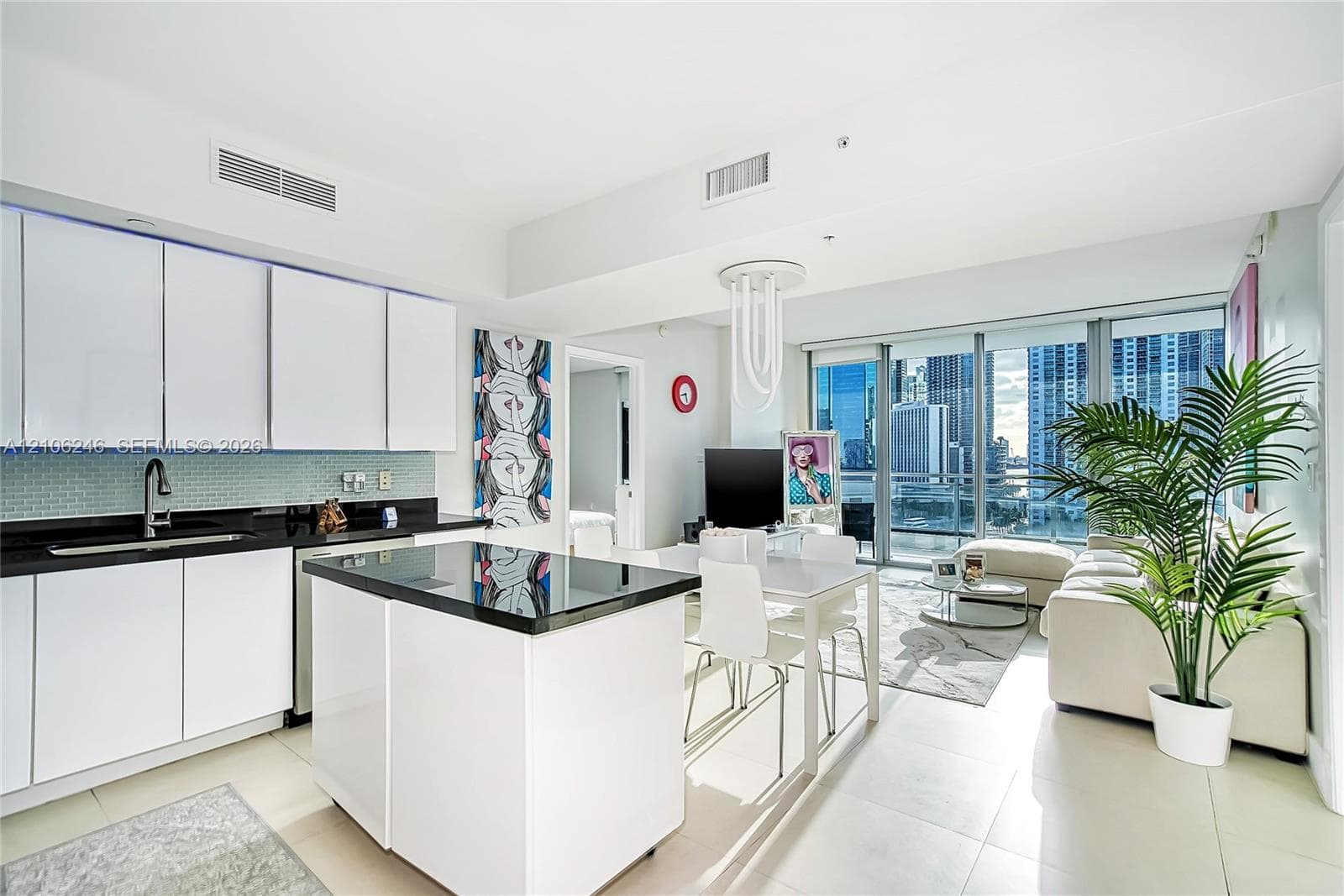 Kitchen featuring flat-panel white cabinetry, black stone countertops, tile backsplash, a matching center island, and floor-to-ceiling glass windows