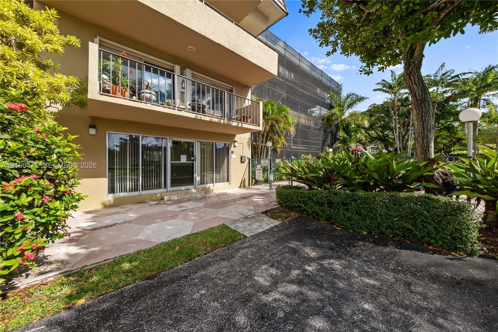 Exterior patio featuring stone pavers and a private balcony with metal railings