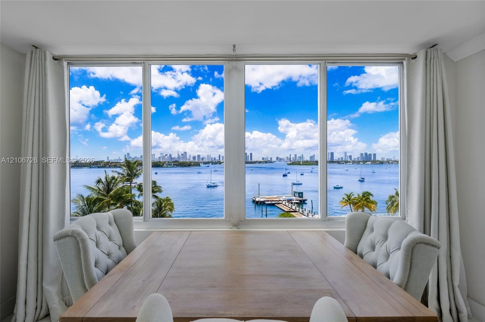 Large format picture windows featuring expansive water, marina, and skyline scenes