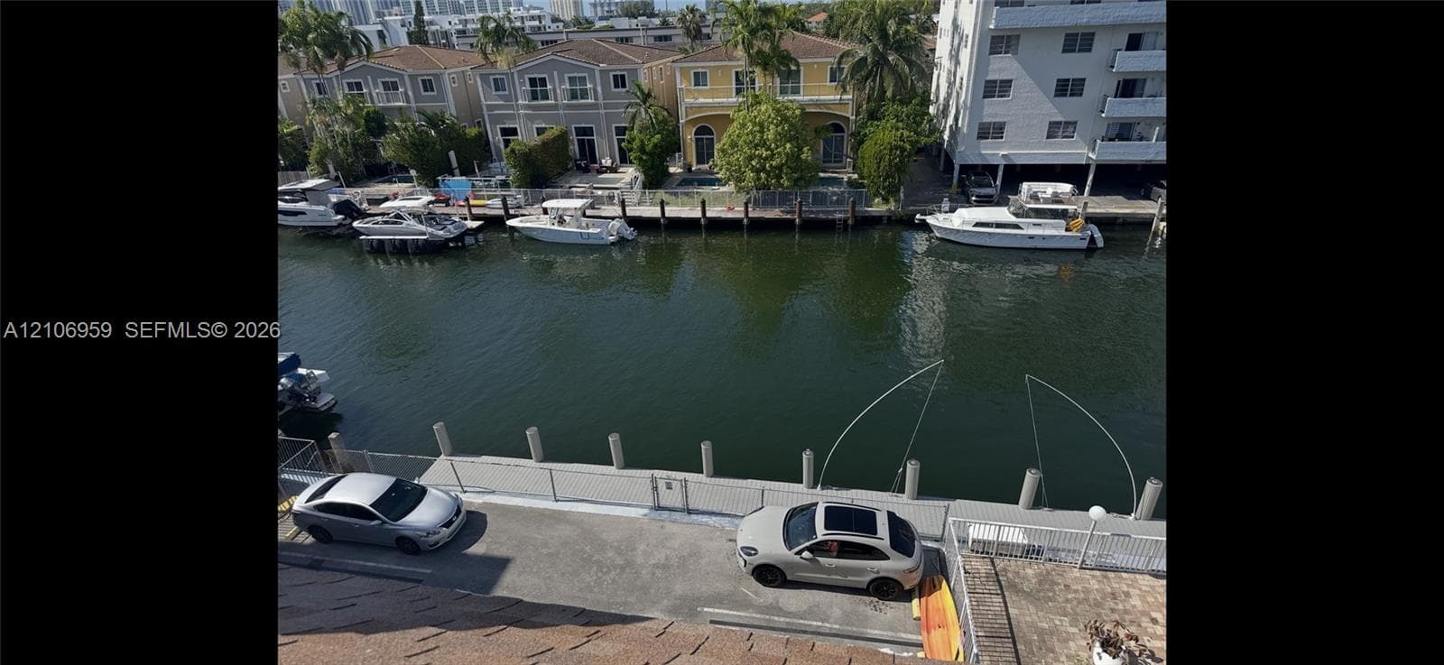 Waterfront property featuring a concrete bulkhead, private dock space, and metal perimeter fencing