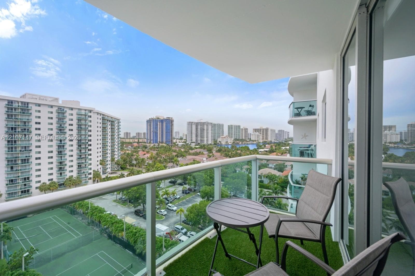 Covered balcony featuring glass pane railings and metal frame finish