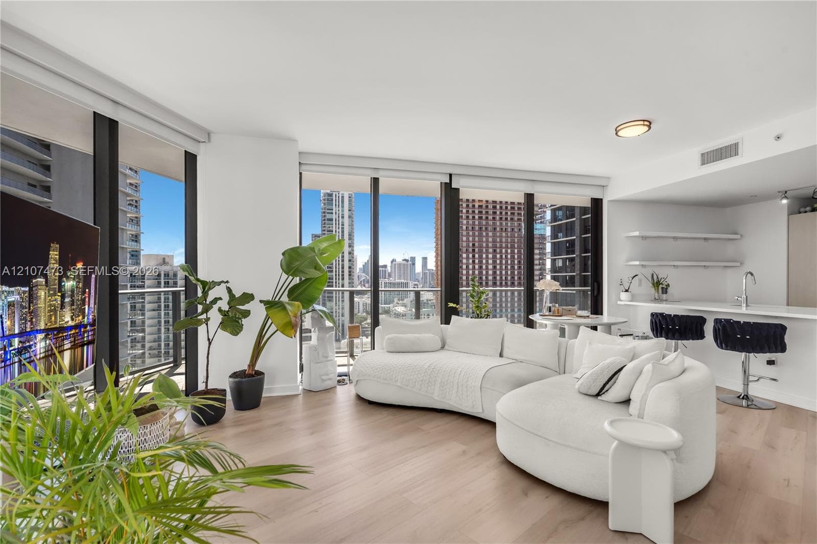 Floor-to-ceiling windows, wood-finish flooring, built-in kitchen breakfast bar, and open-concept layout