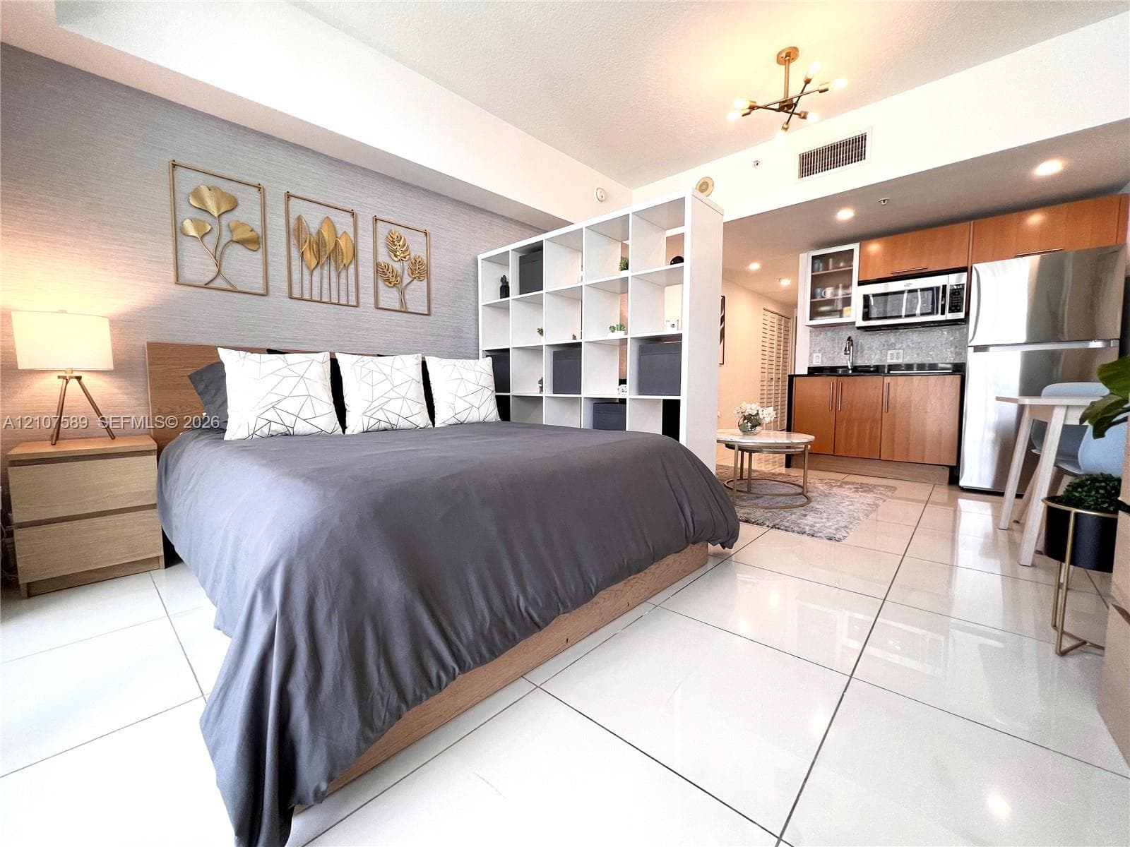 Polished tile flooring, textured accent wall, and contemporary multi-arm ceiling lighting