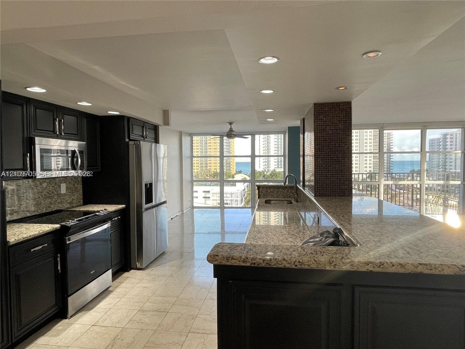 Kitchen featuring dark cabinetry, stone countertops, stainless steel appliances, tile flooring, and recessed lighting